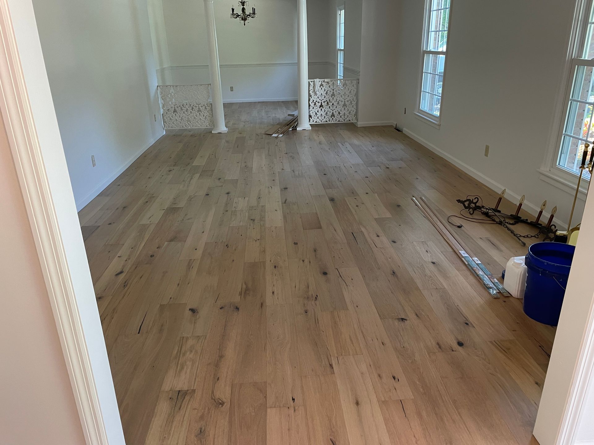 A large empty room with hardwood floors and white walls.