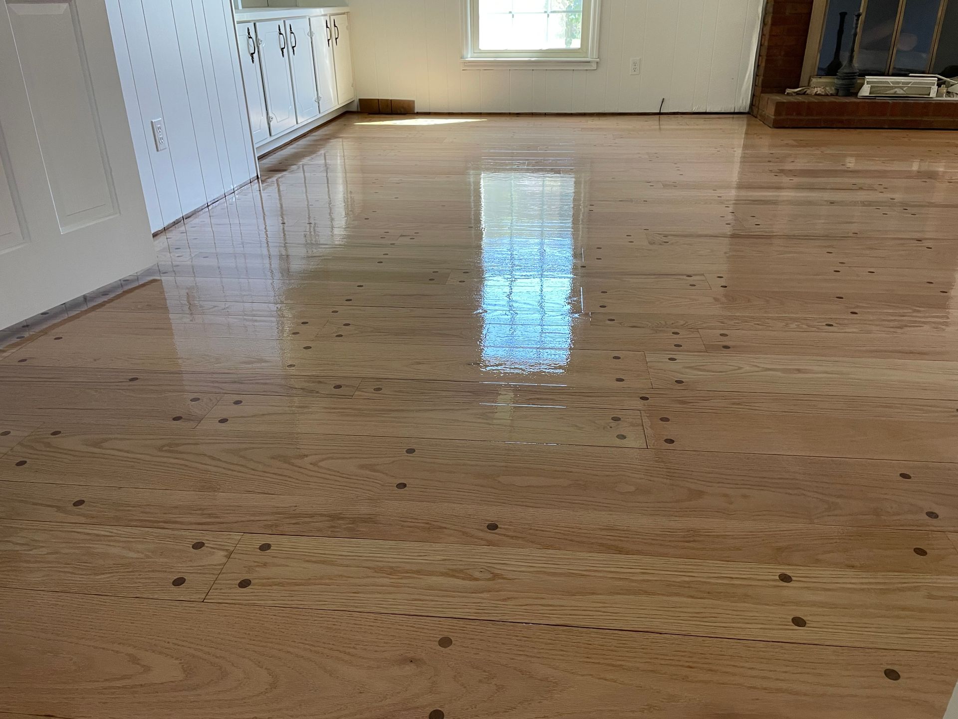 A living room with a wooden floor and a fireplace.