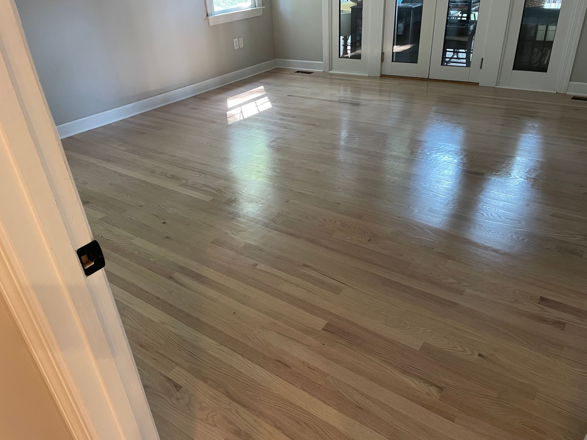 A living room with hardwood floors and sliding glass doors.