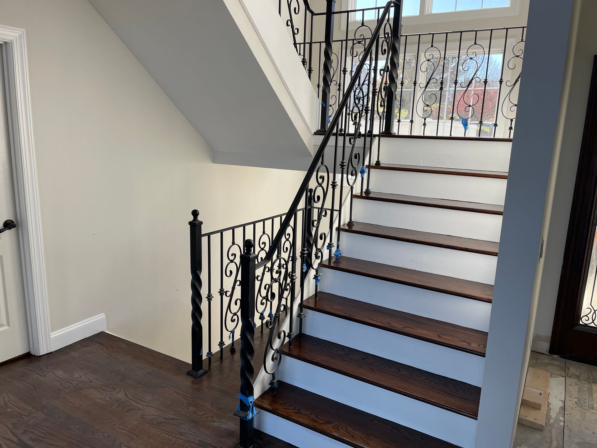 A staircase with a wrought iron railing and wooden steps
