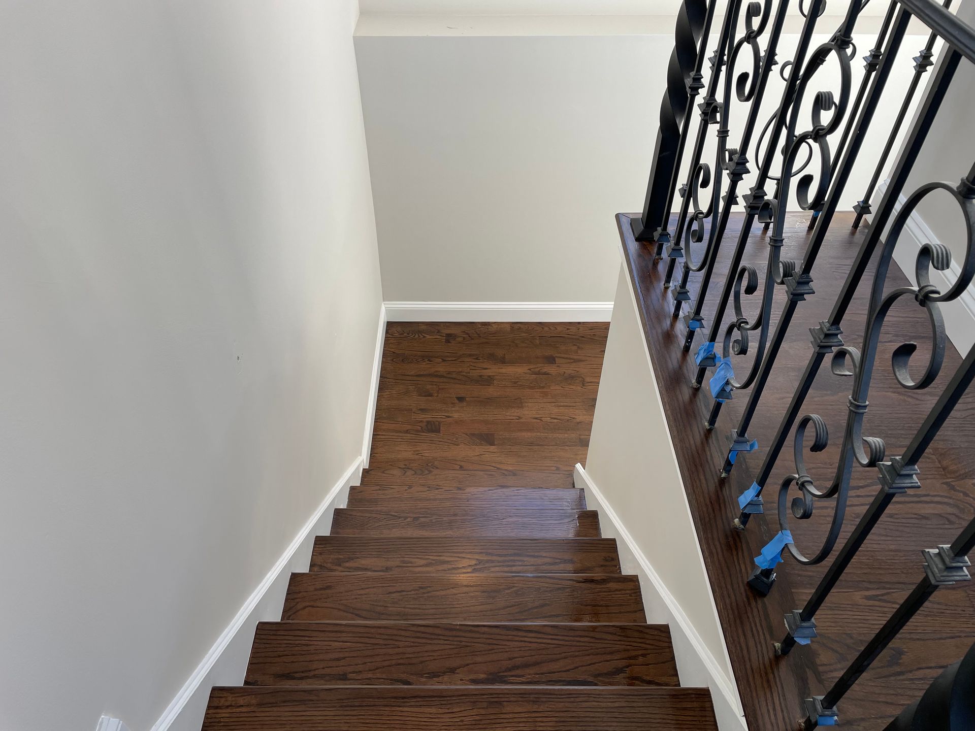 A wooden staircase with a wrought iron railing leading up to the second floor.