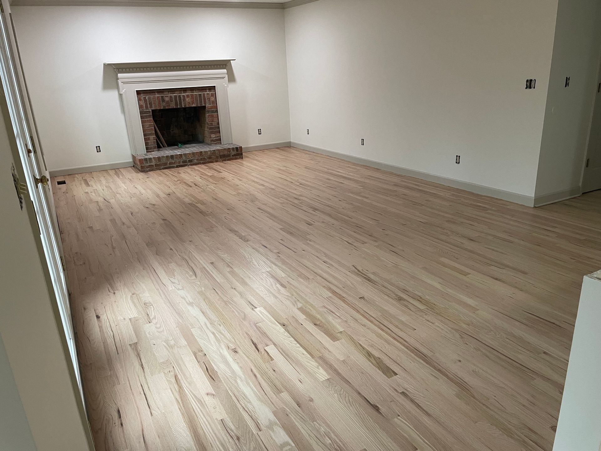 A living room with hardwood floors and a fireplace.