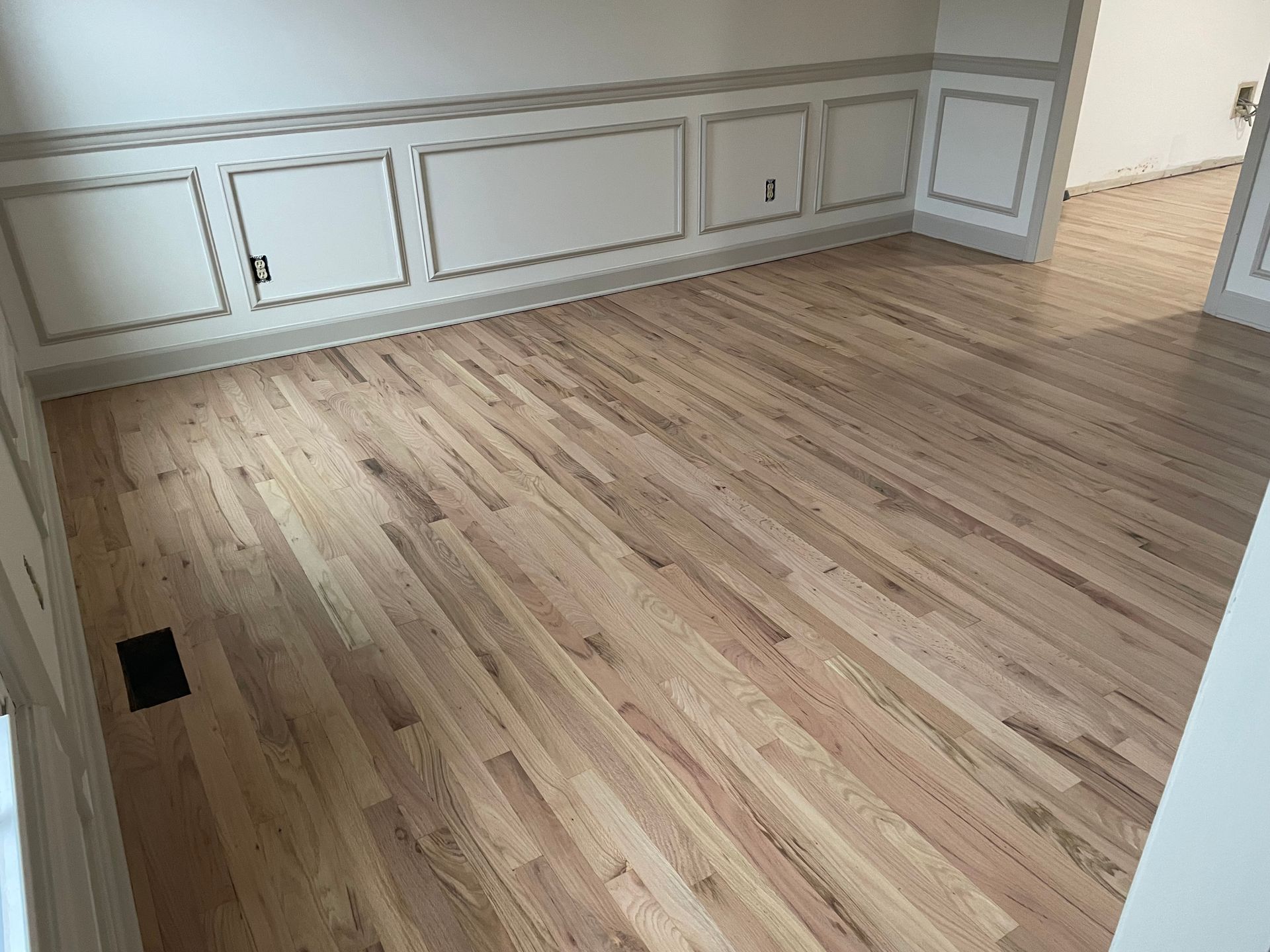 A room with hardwood floors and white walls.