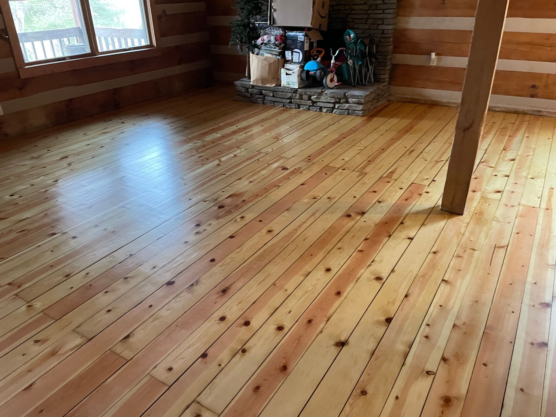 A living room with a wooden floor and a fireplace.