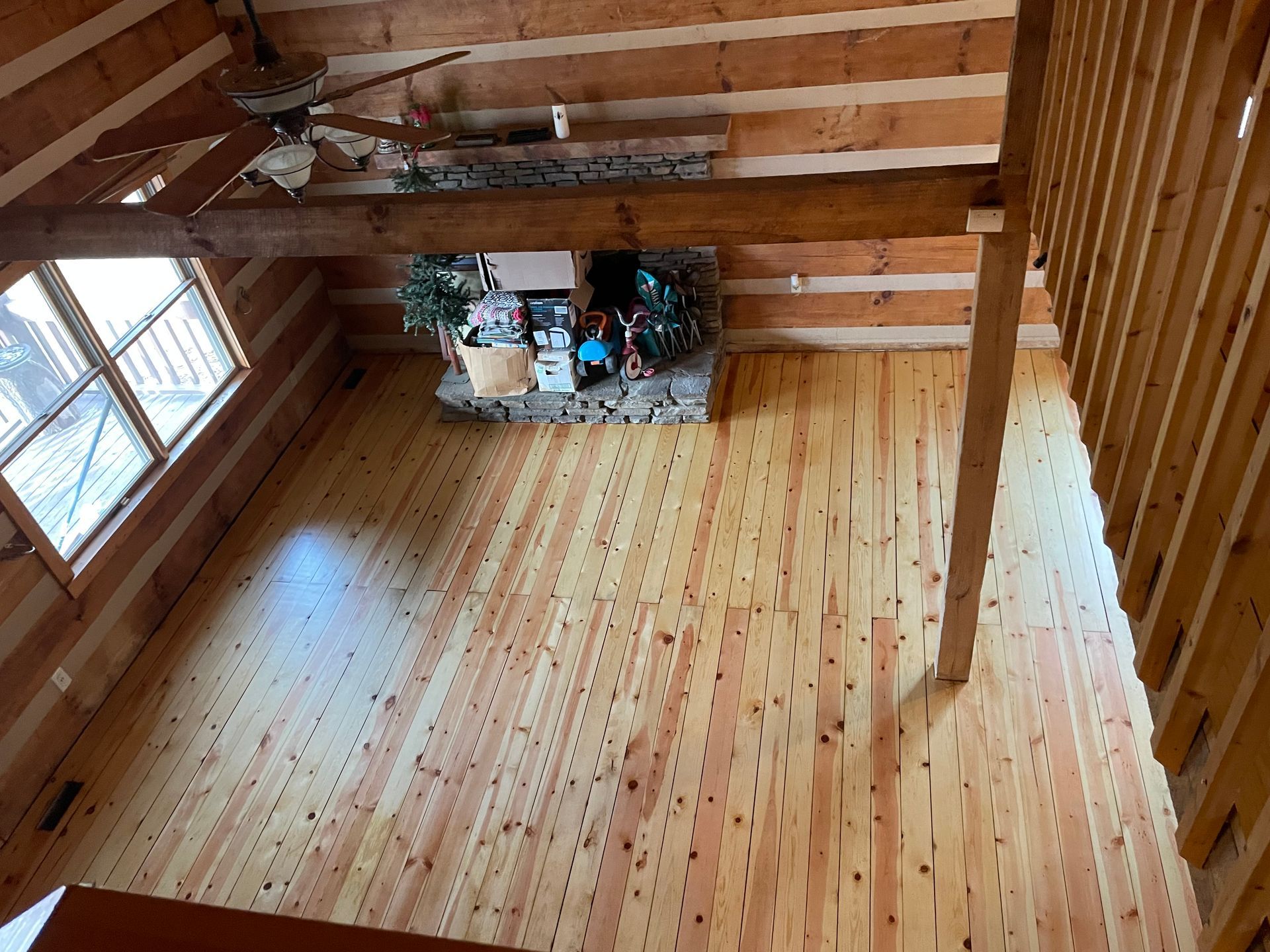 A log cabin with a wooden floor and a fireplace.