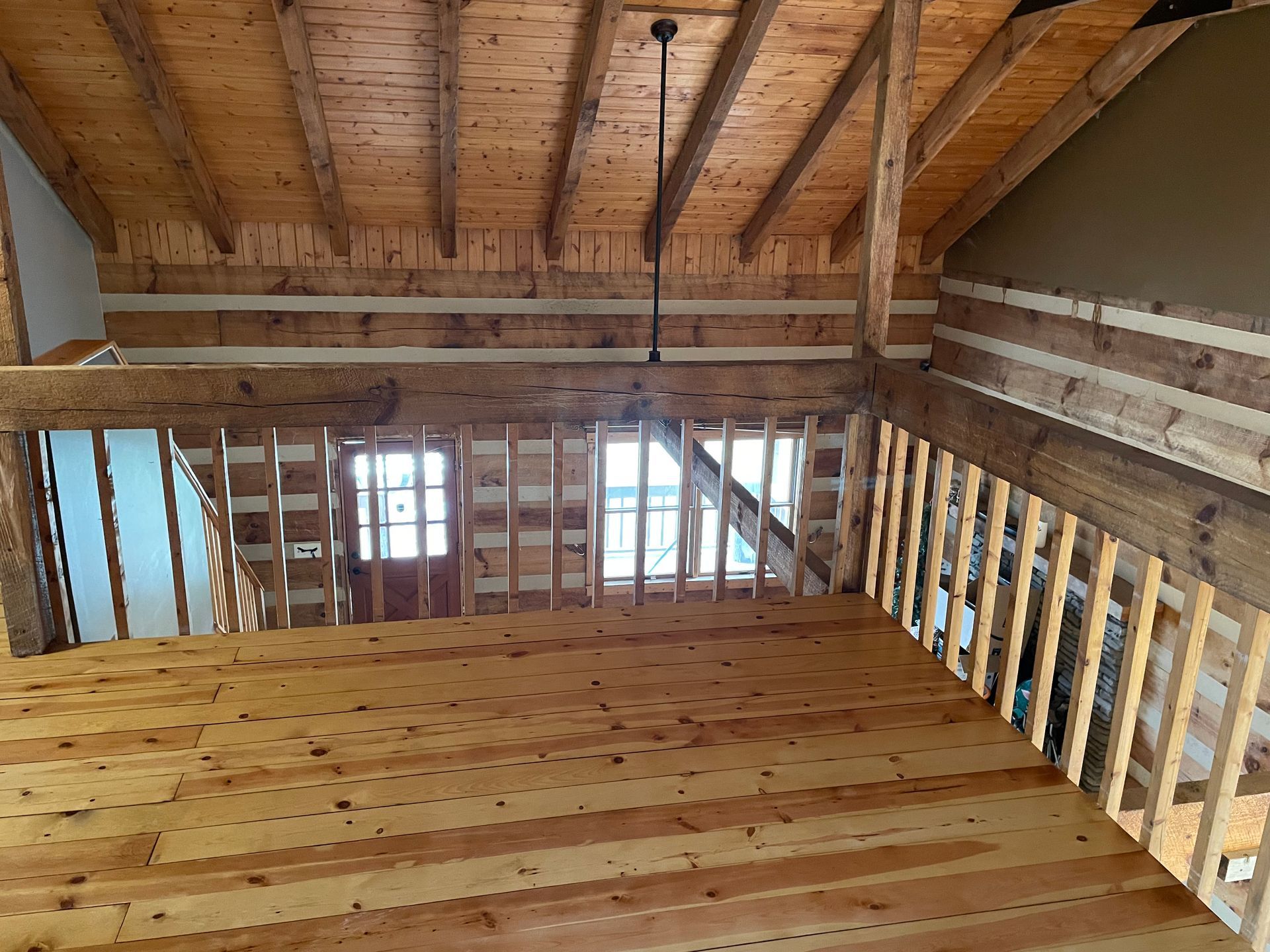 An empty room with wooden floors and a wooden railing