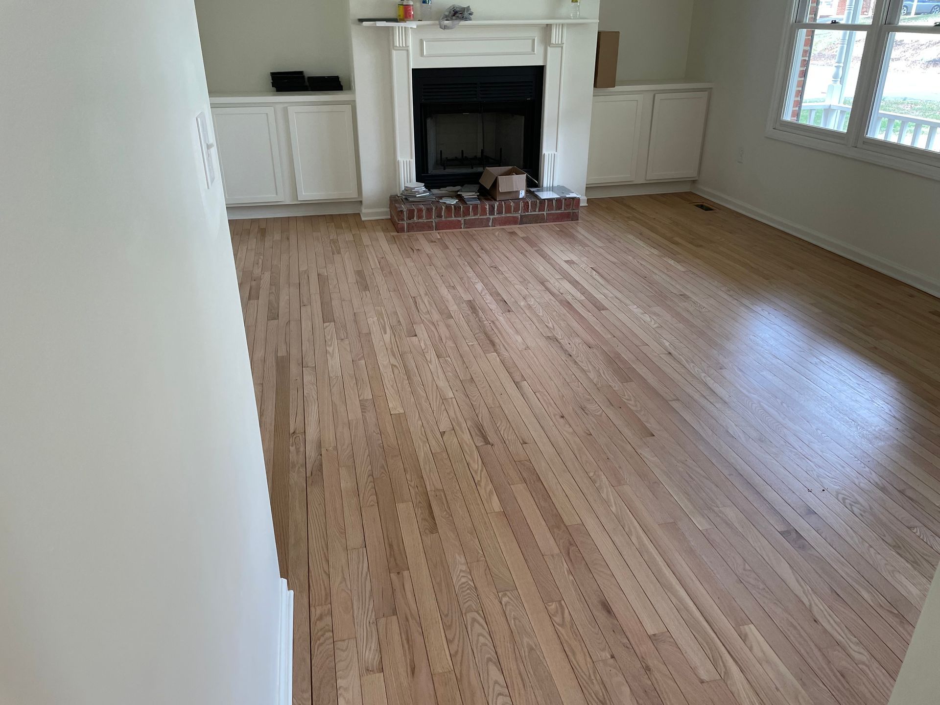 A living room with hardwood floors and a fireplace.