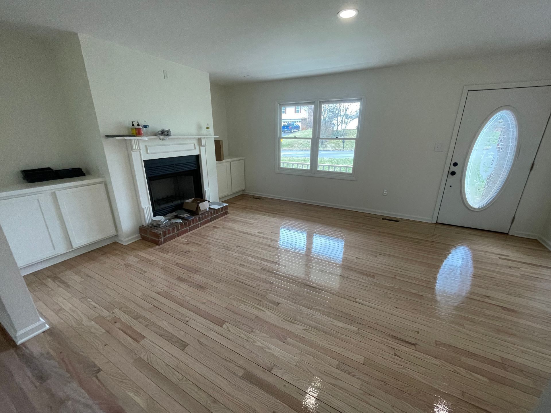 A living room with hardwood floors and a fireplace.