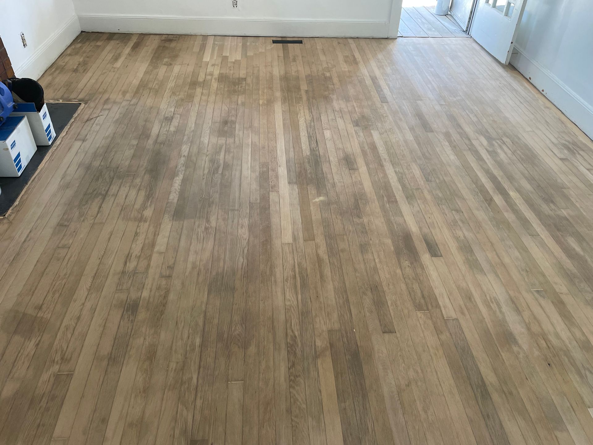 A wooden floor in a room with white walls