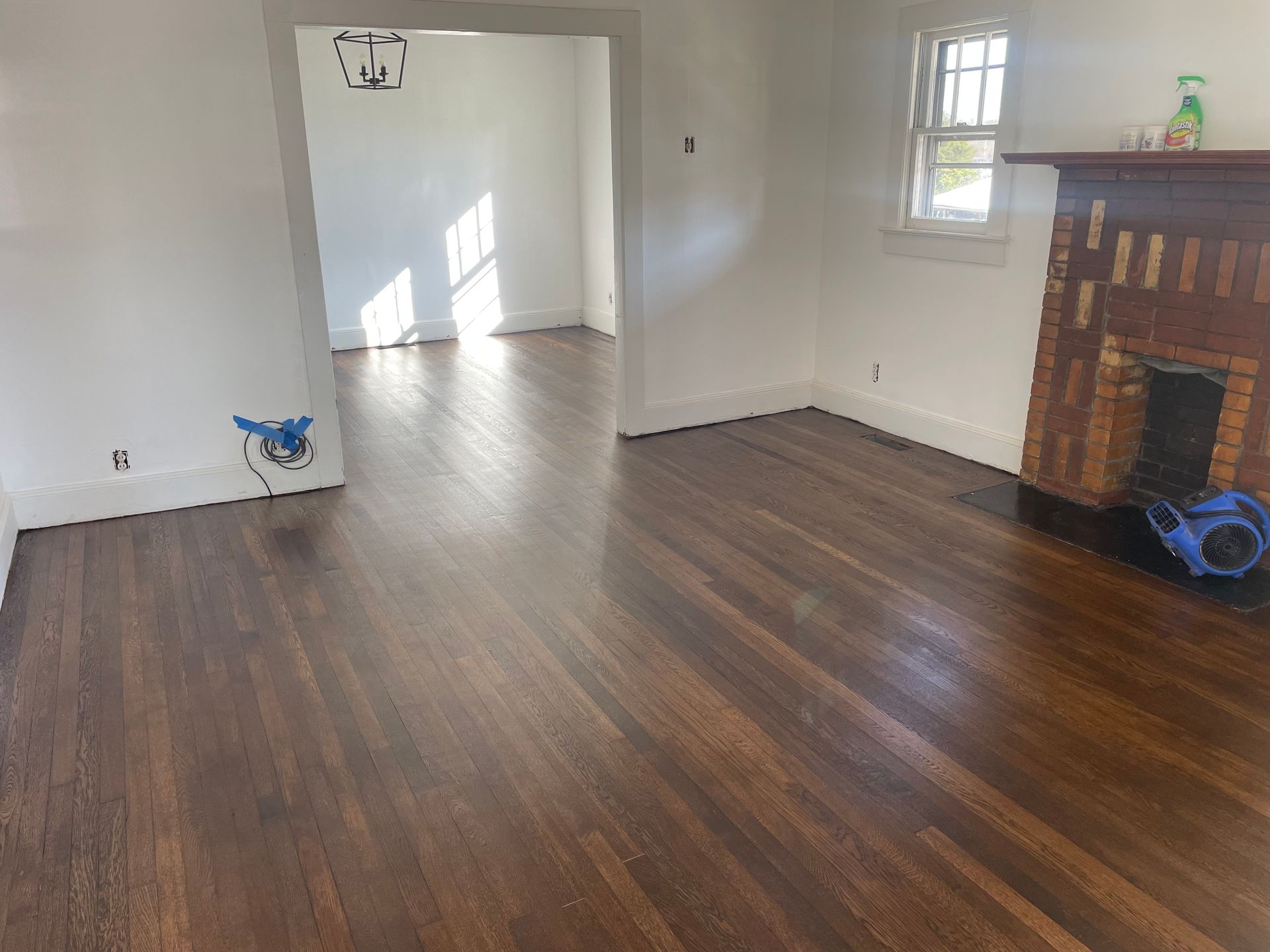 An empty living room with hardwood floors and a fireplace.