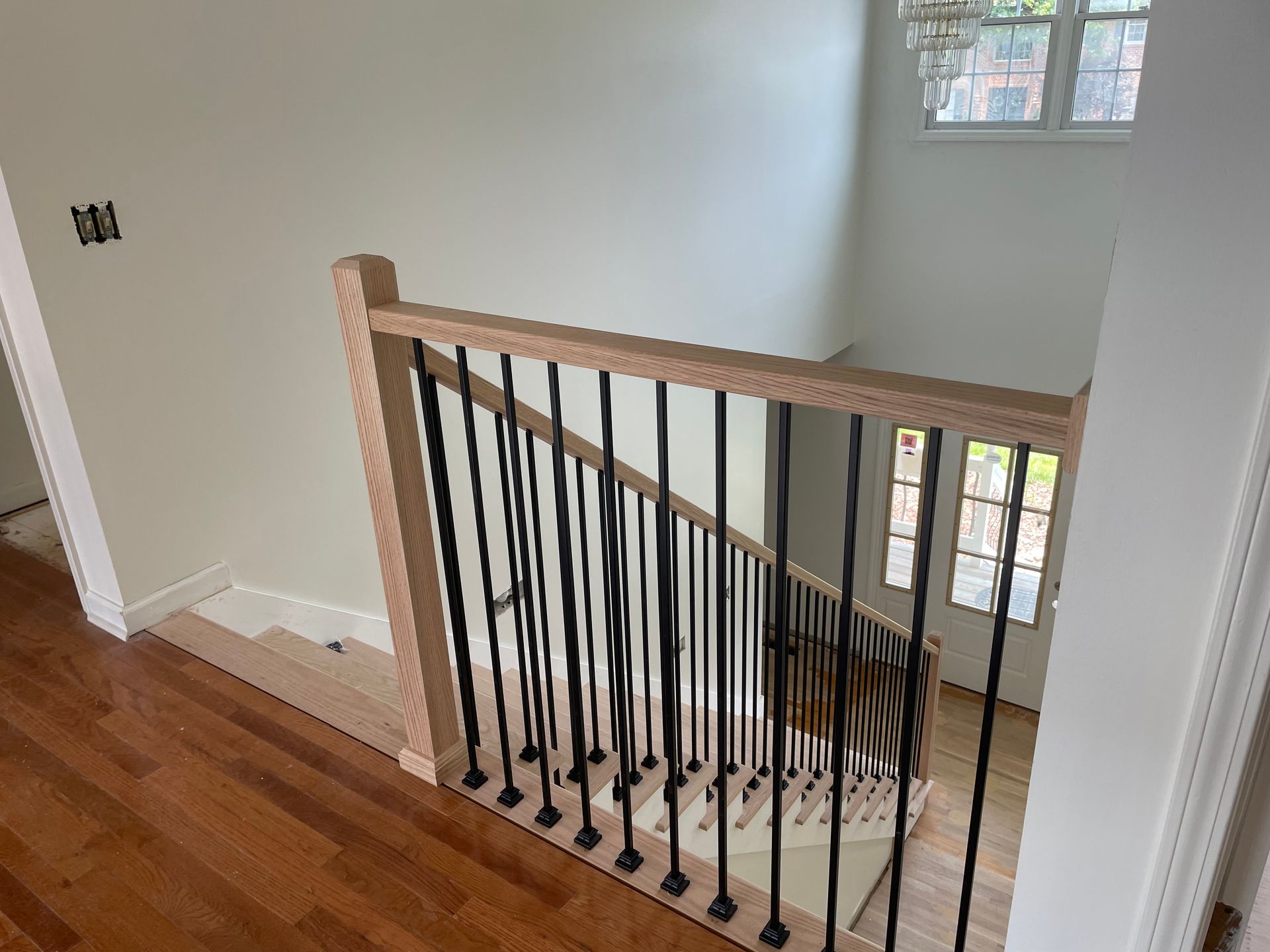 A wooden staircase with a black railing in a house.