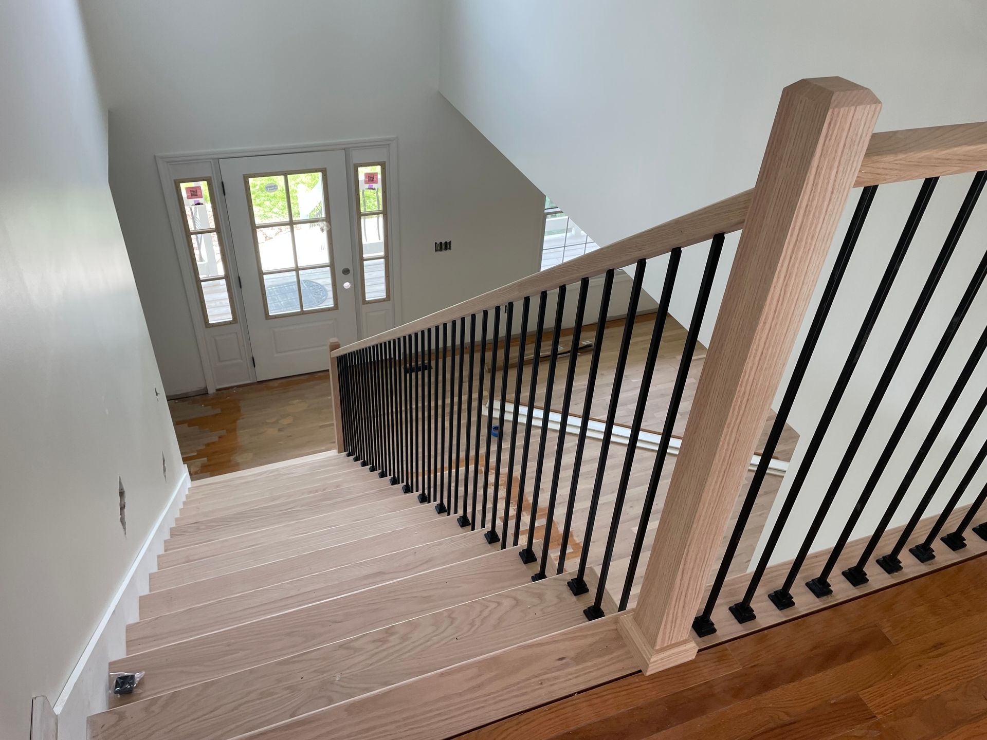 A wooden staircase with a black railing in a house.