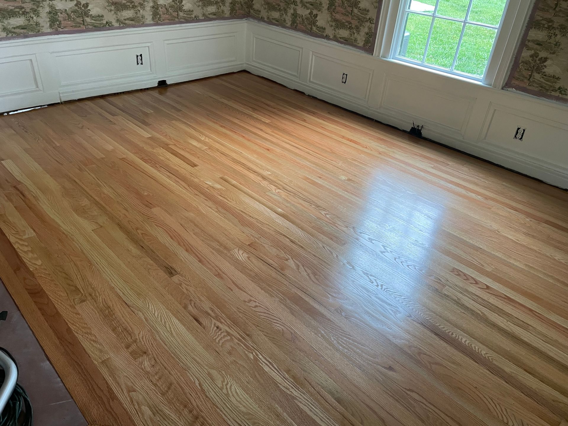 A room with a wooden floor and a window.