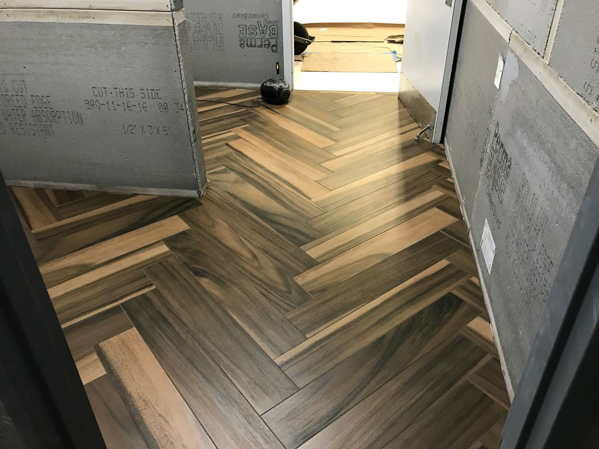 A hallway with a wooden floor in a herringbone pattern