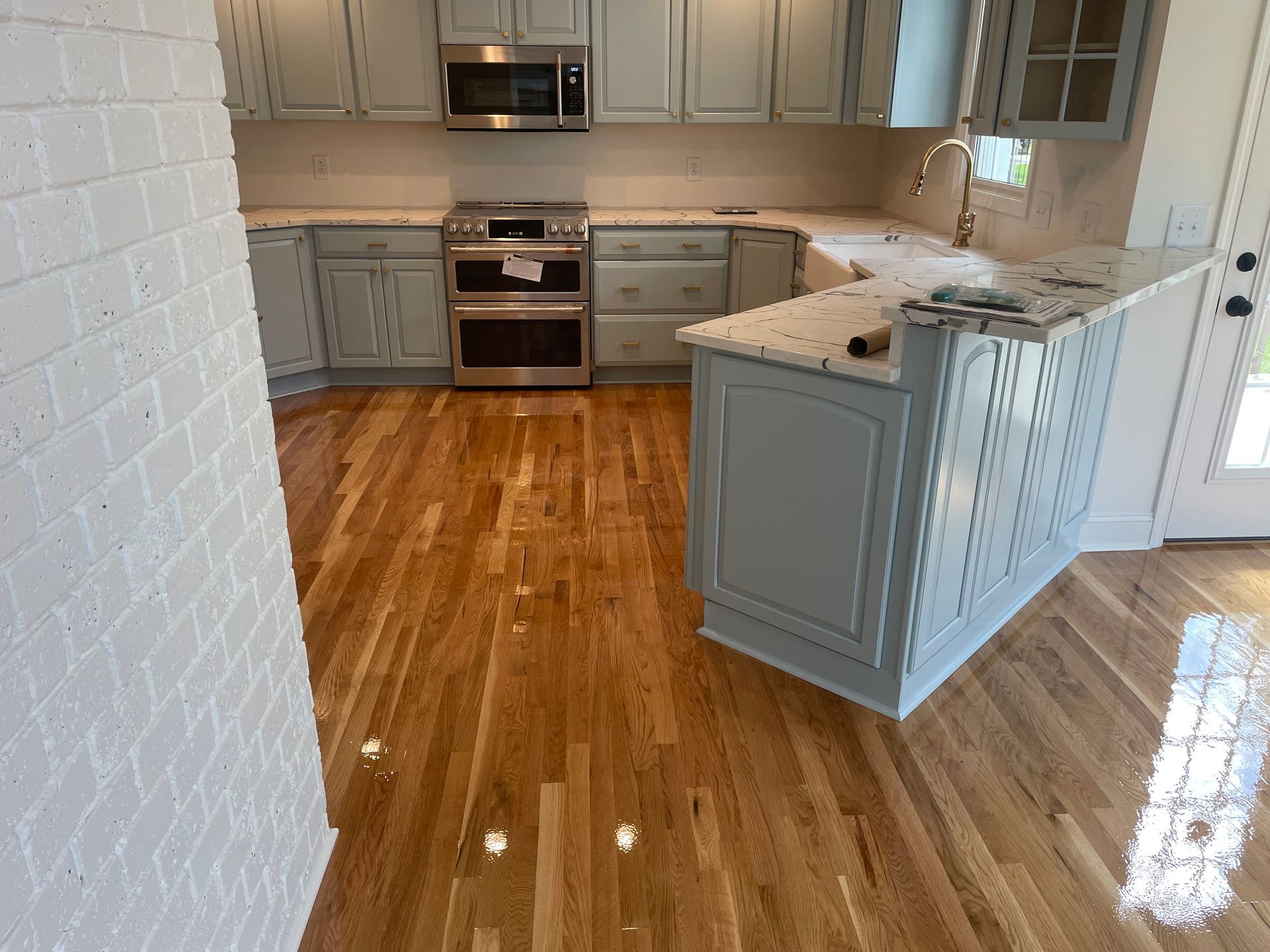 A kitchen with hardwood floors and stainless steel appliances.