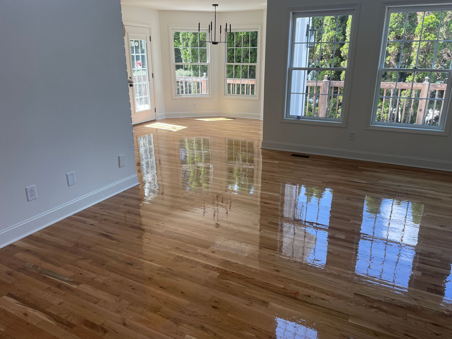 A living room with hardwood floors and lots of windows.