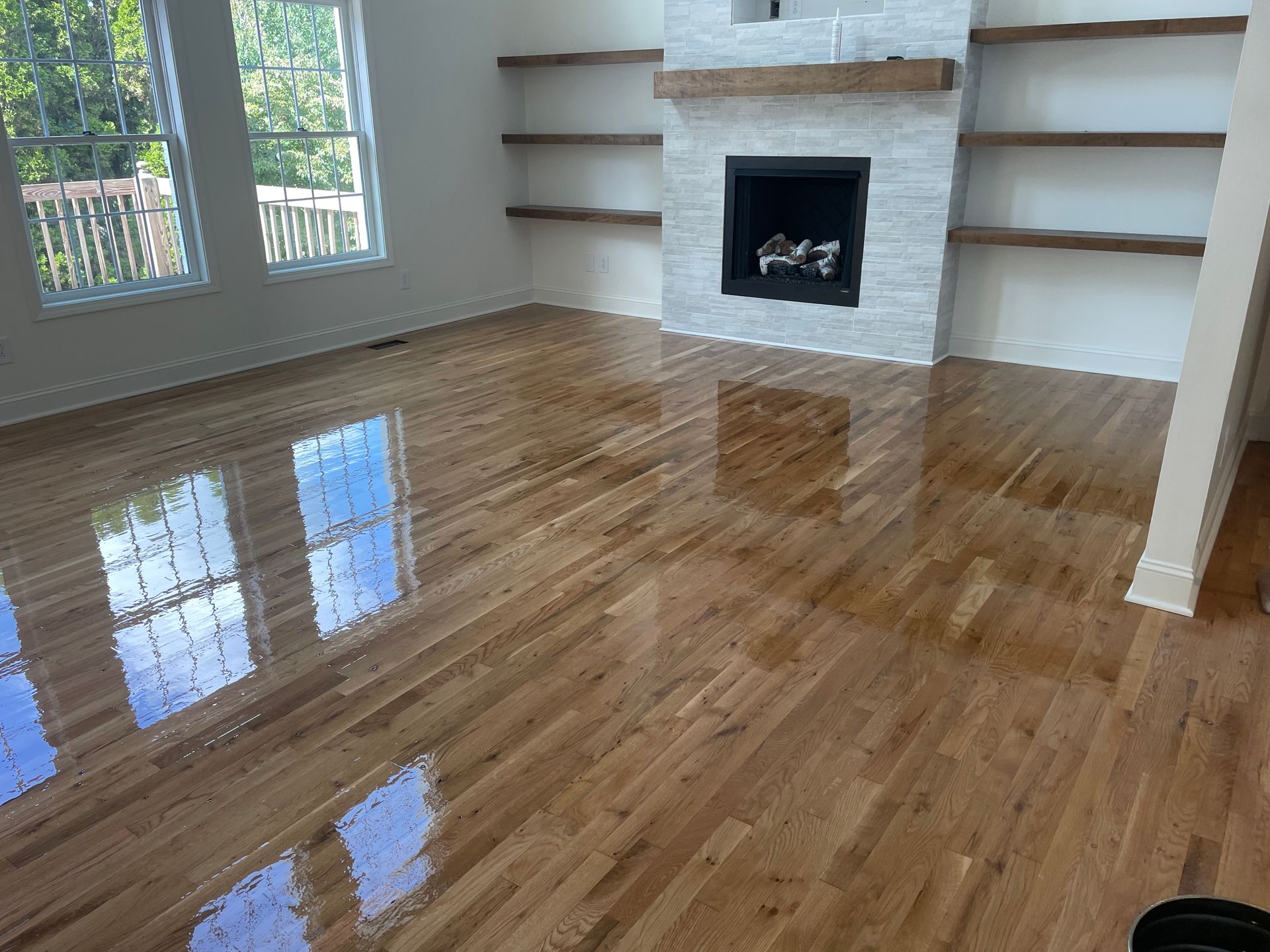 A living room with hardwood floors and a fireplace.