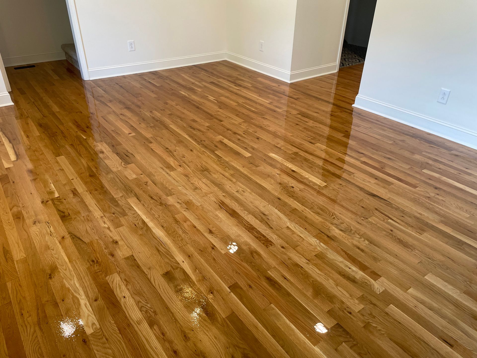 A living room with hardwood floors and white walls.