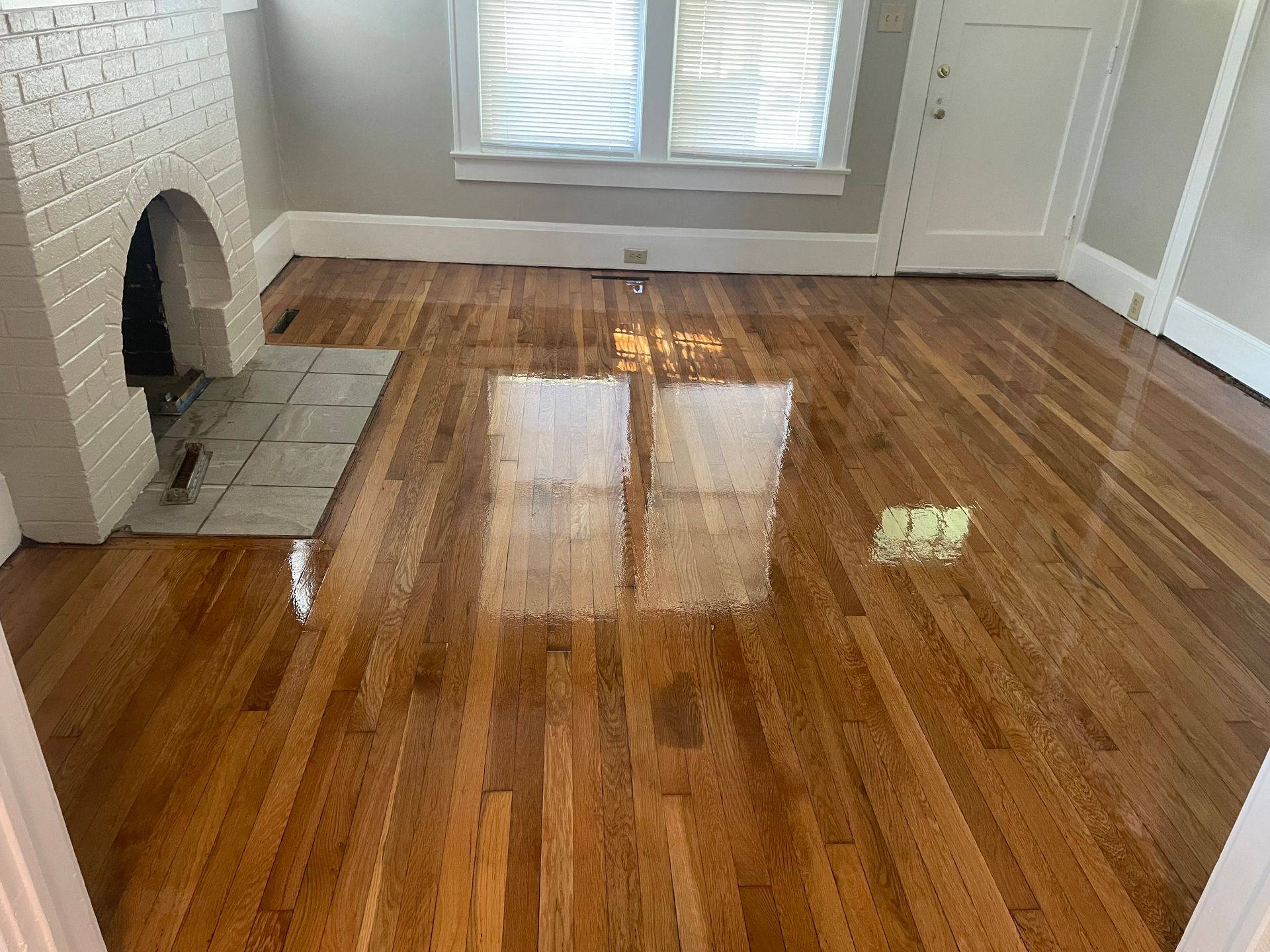 A living room with hardwood floors and a fireplace.
