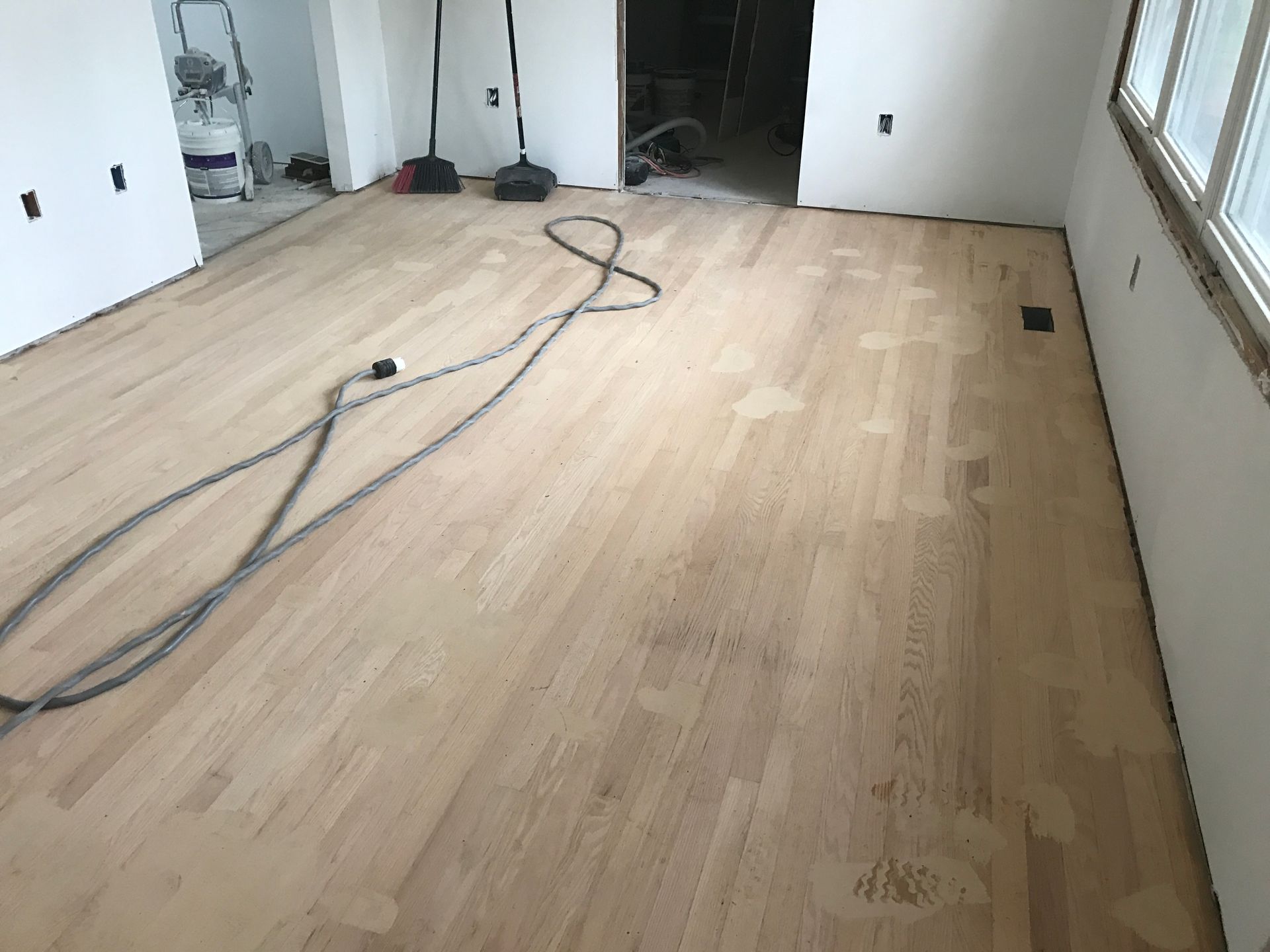 A room with a wooden floor and a vacuum cleaner on it.