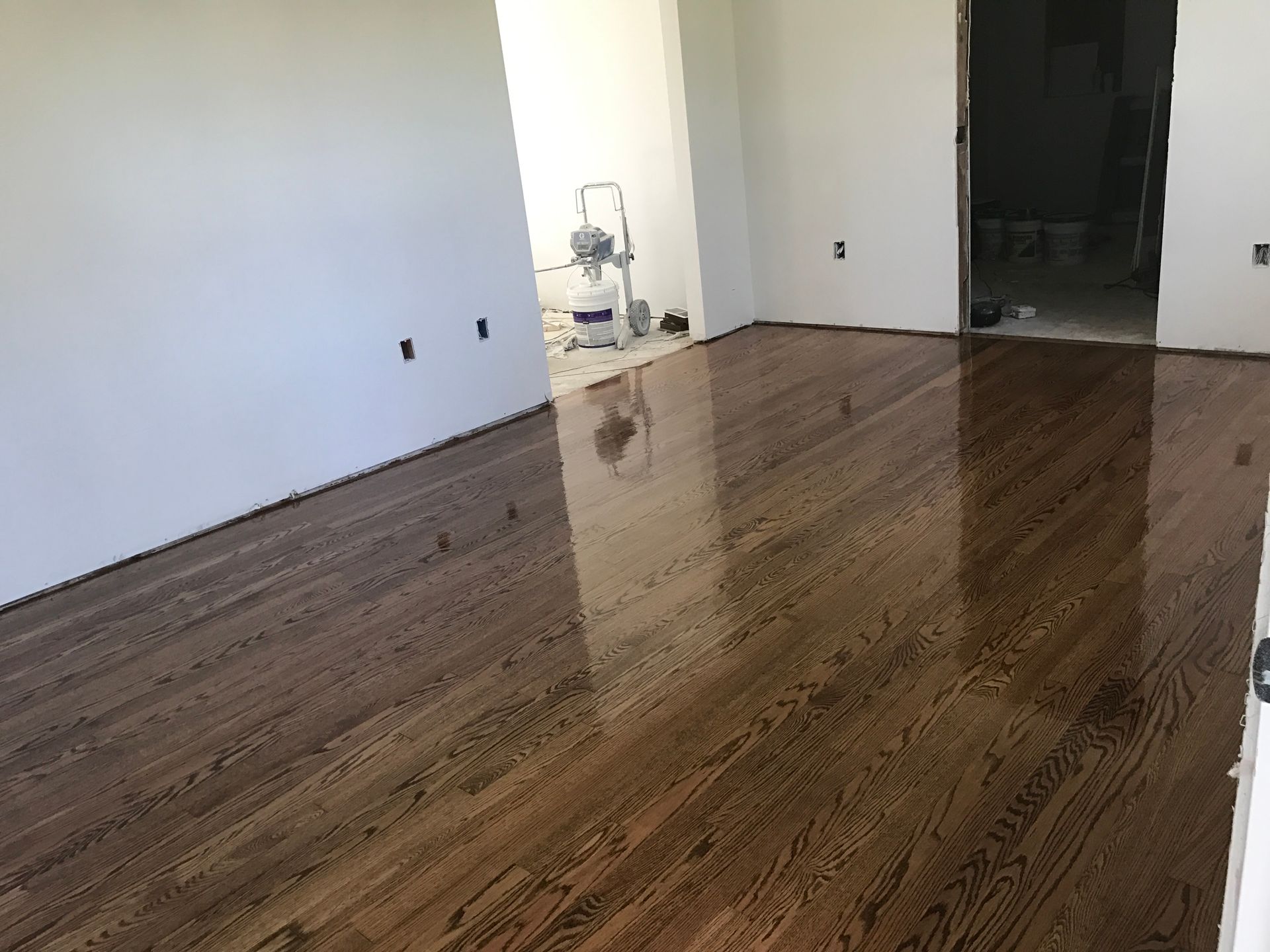 A living room with hardwood floors and white walls.