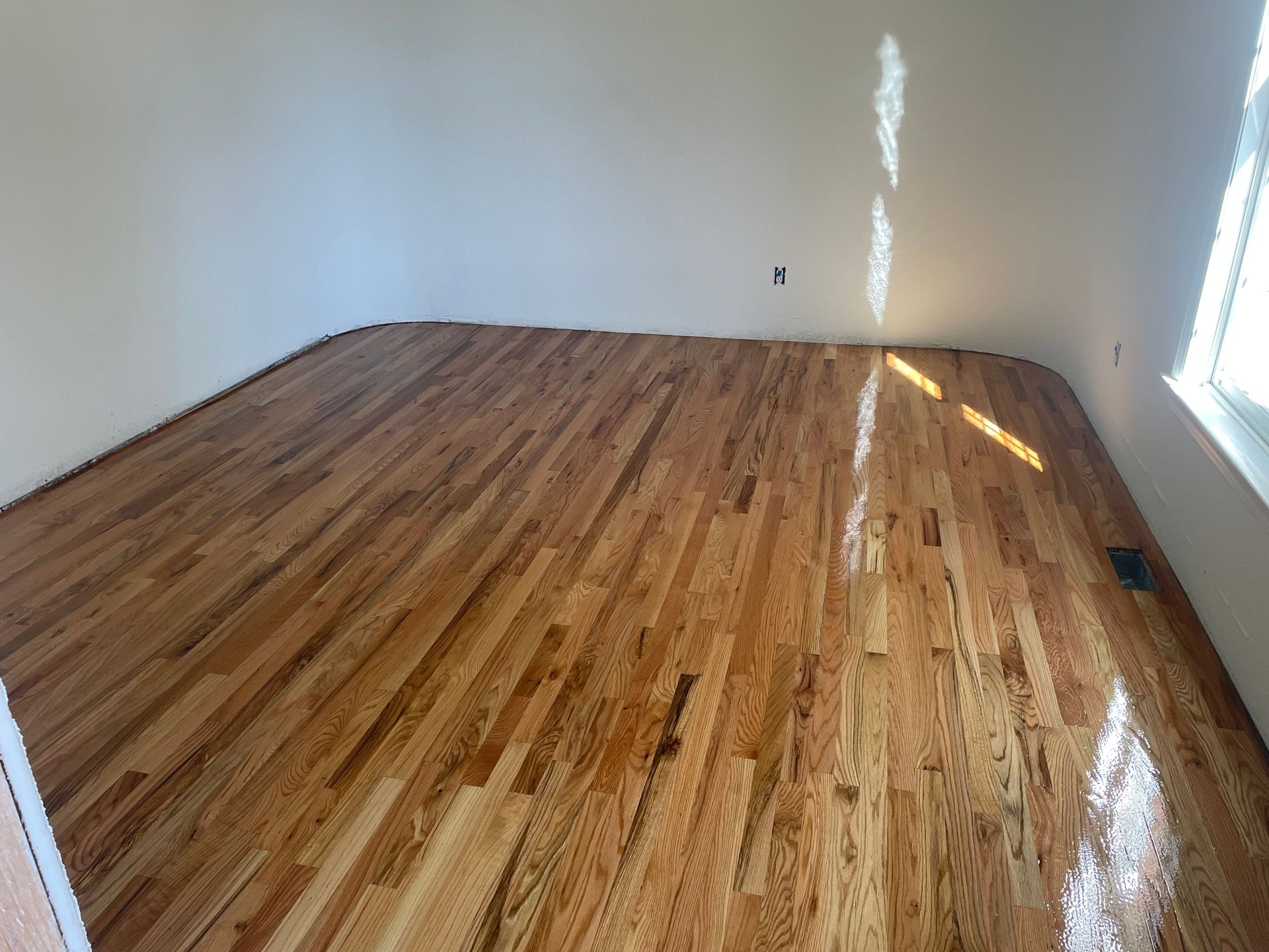 A room with hardwood floors and white walls.
