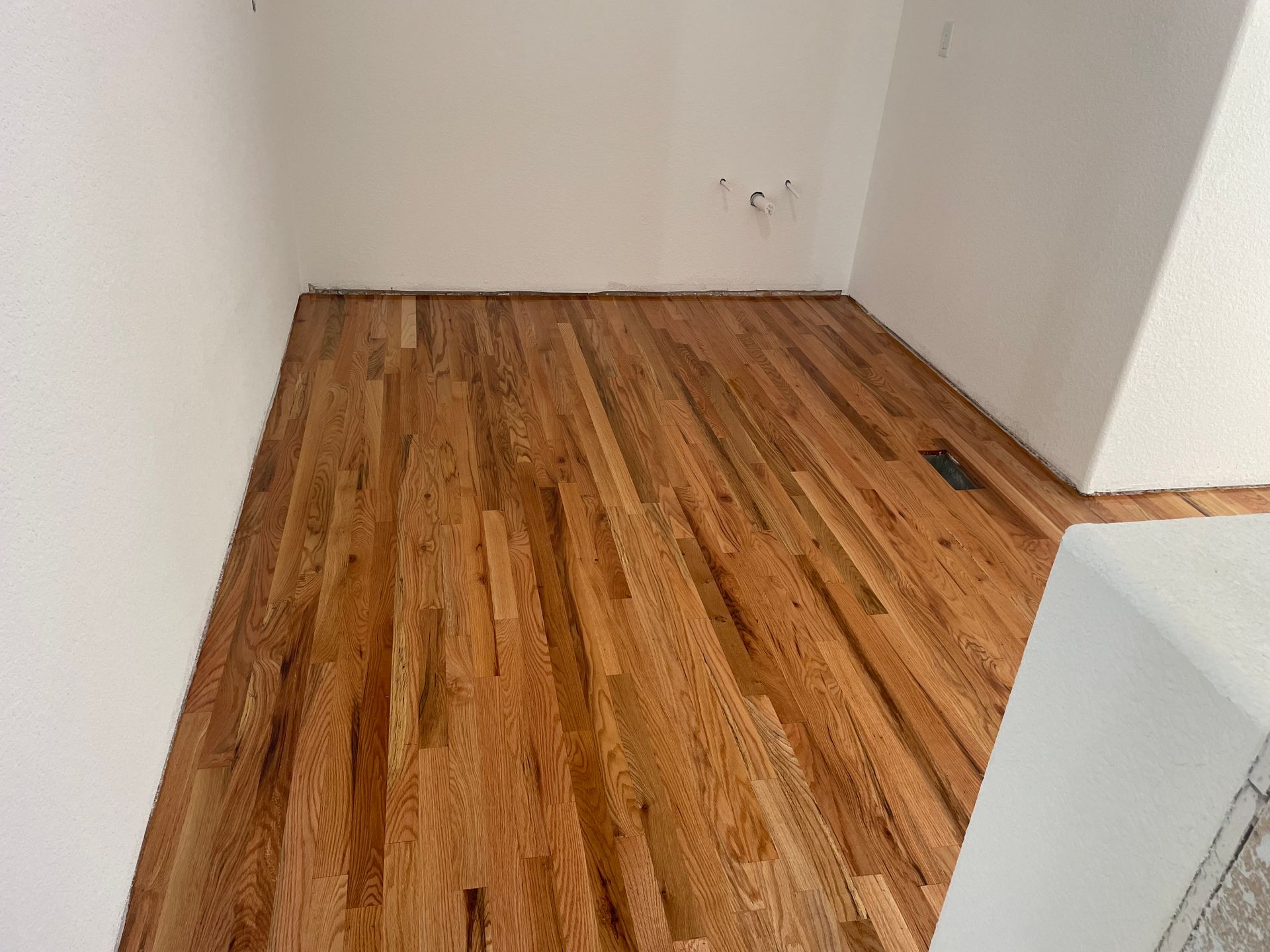 A room with a wooden floor and white walls