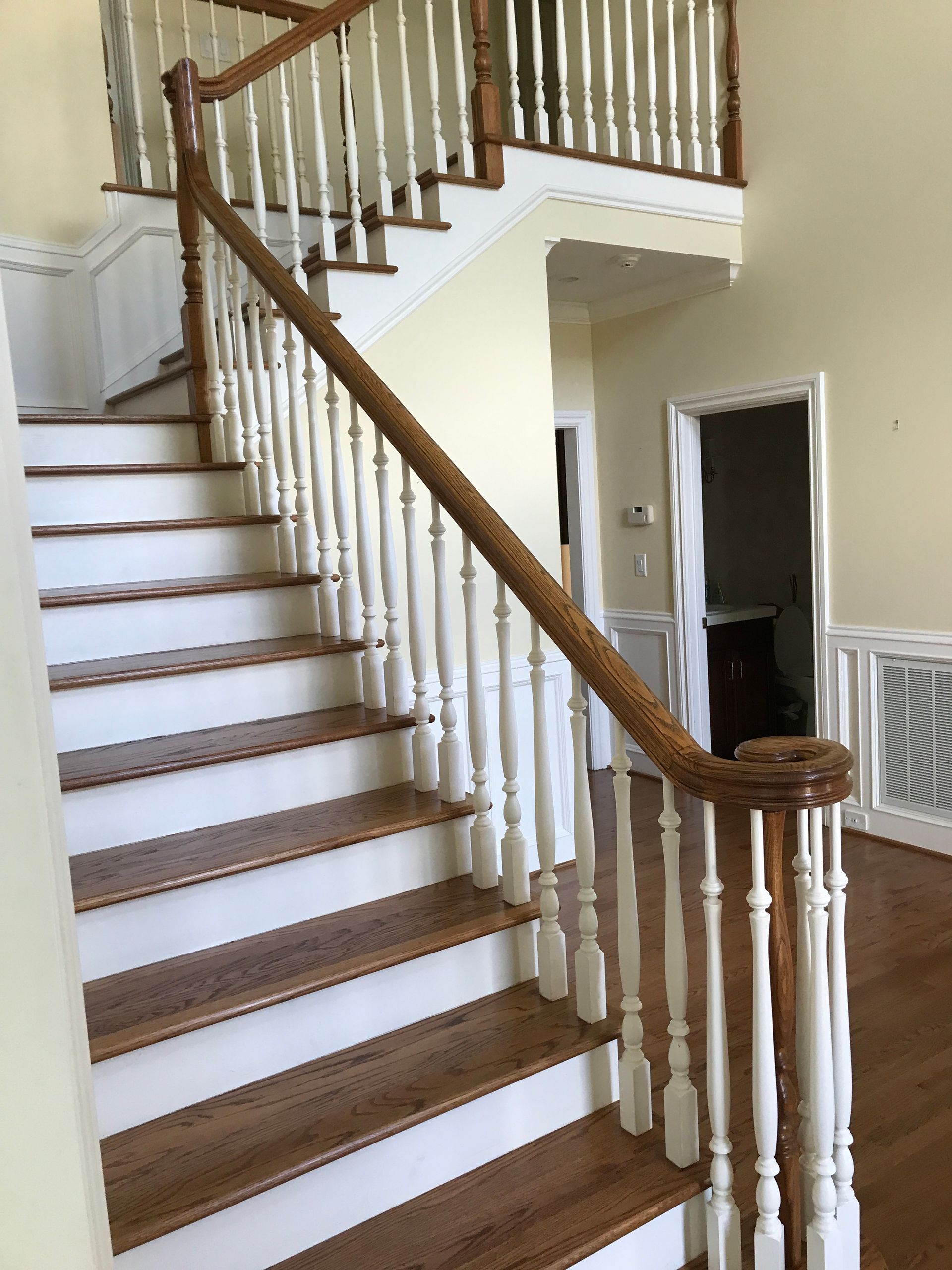 A staircase with wooden steps and white railings in a house