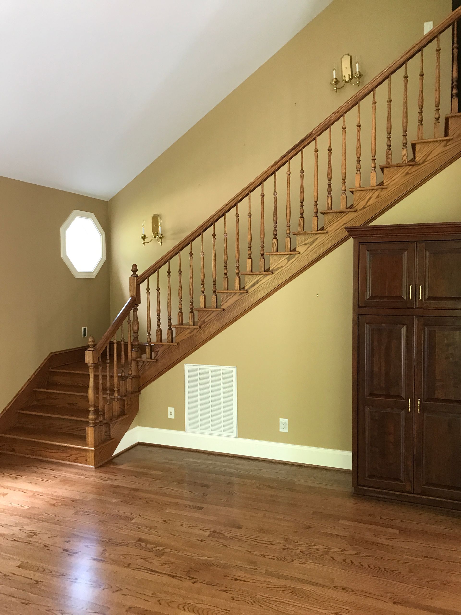 A wooden staircase in an empty room with hardwood floors
