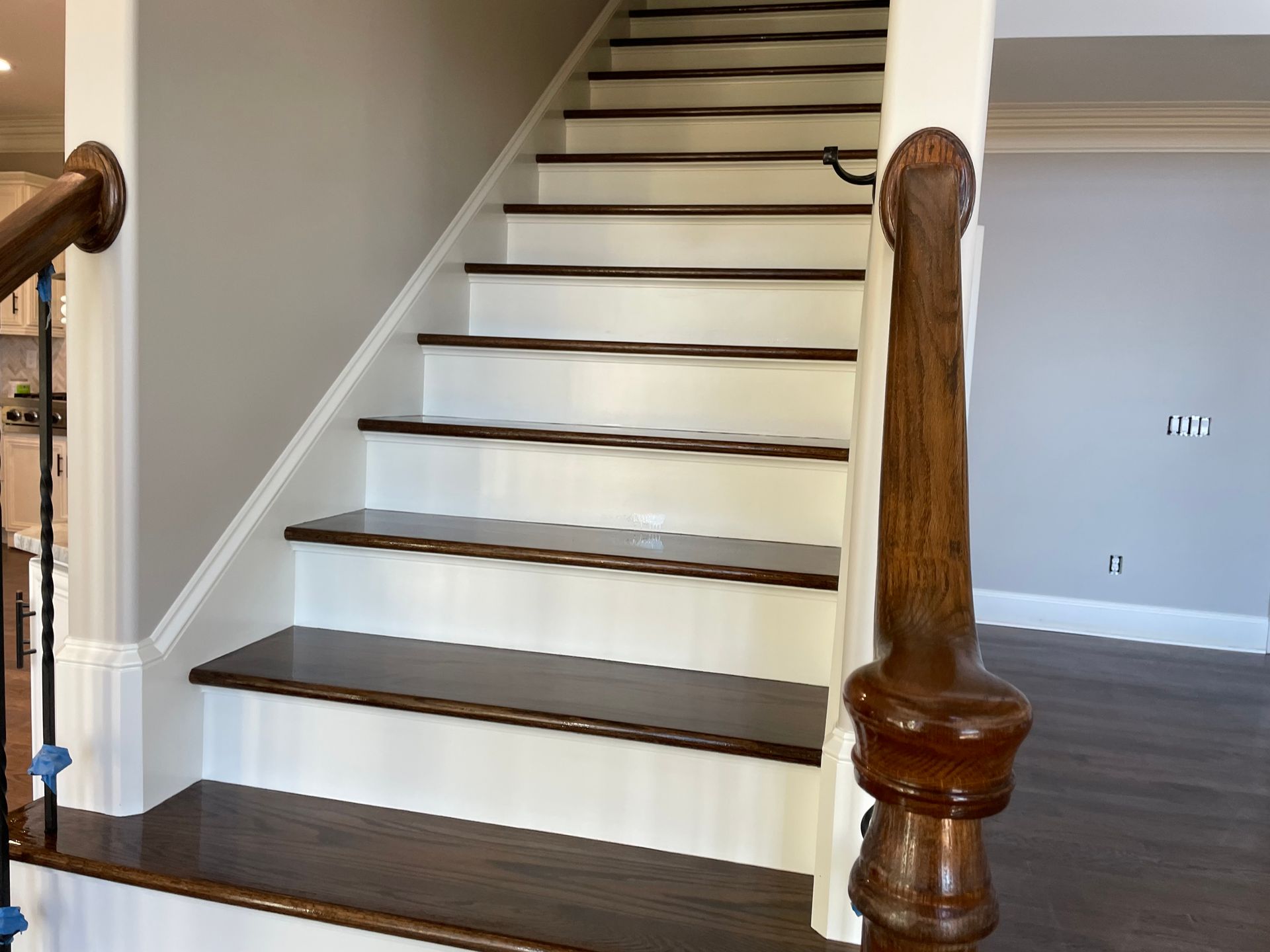A wooden staircase with white steps and a wooden railing in a house.