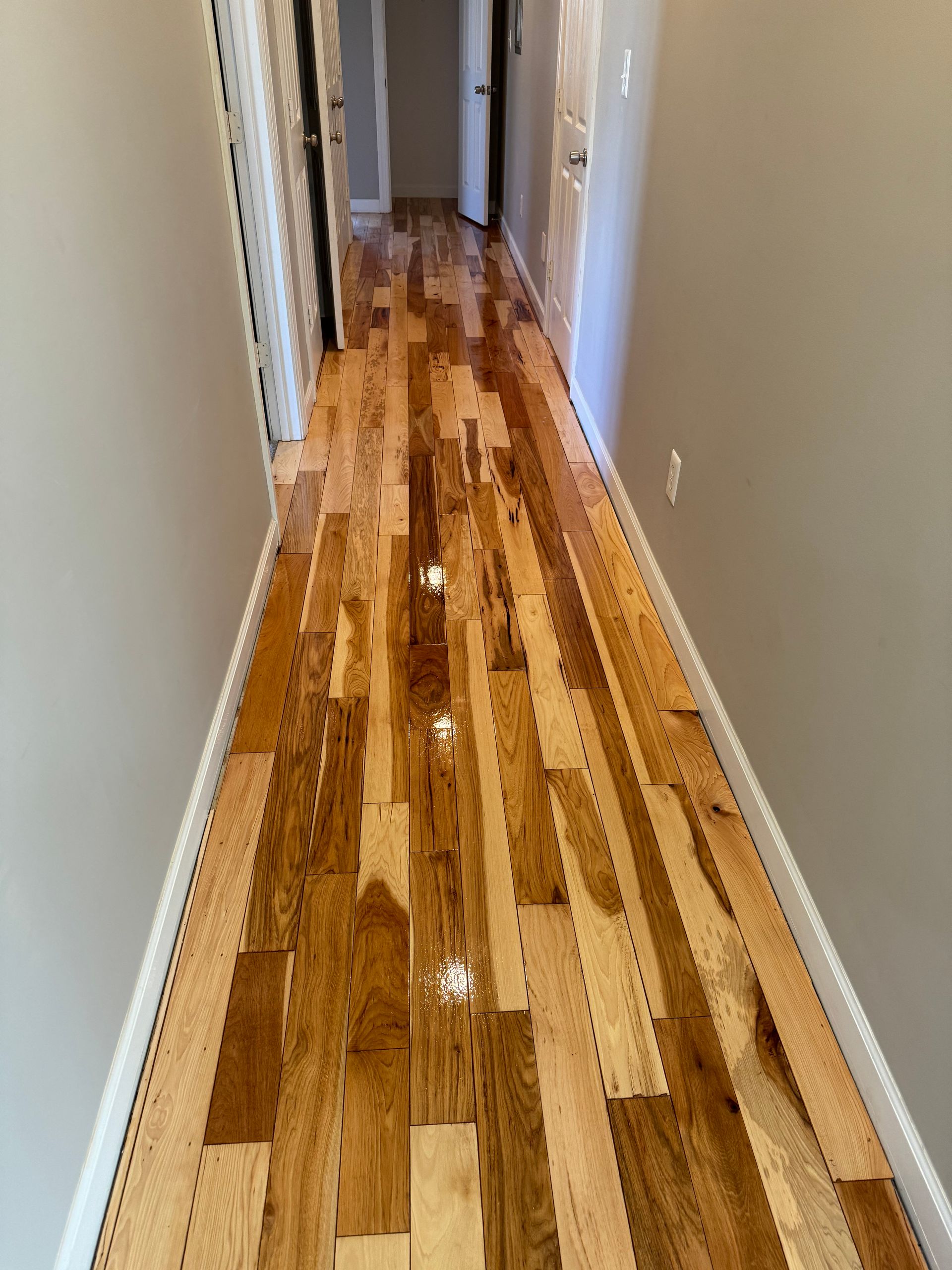 A hallway with hardwood floors in a house.