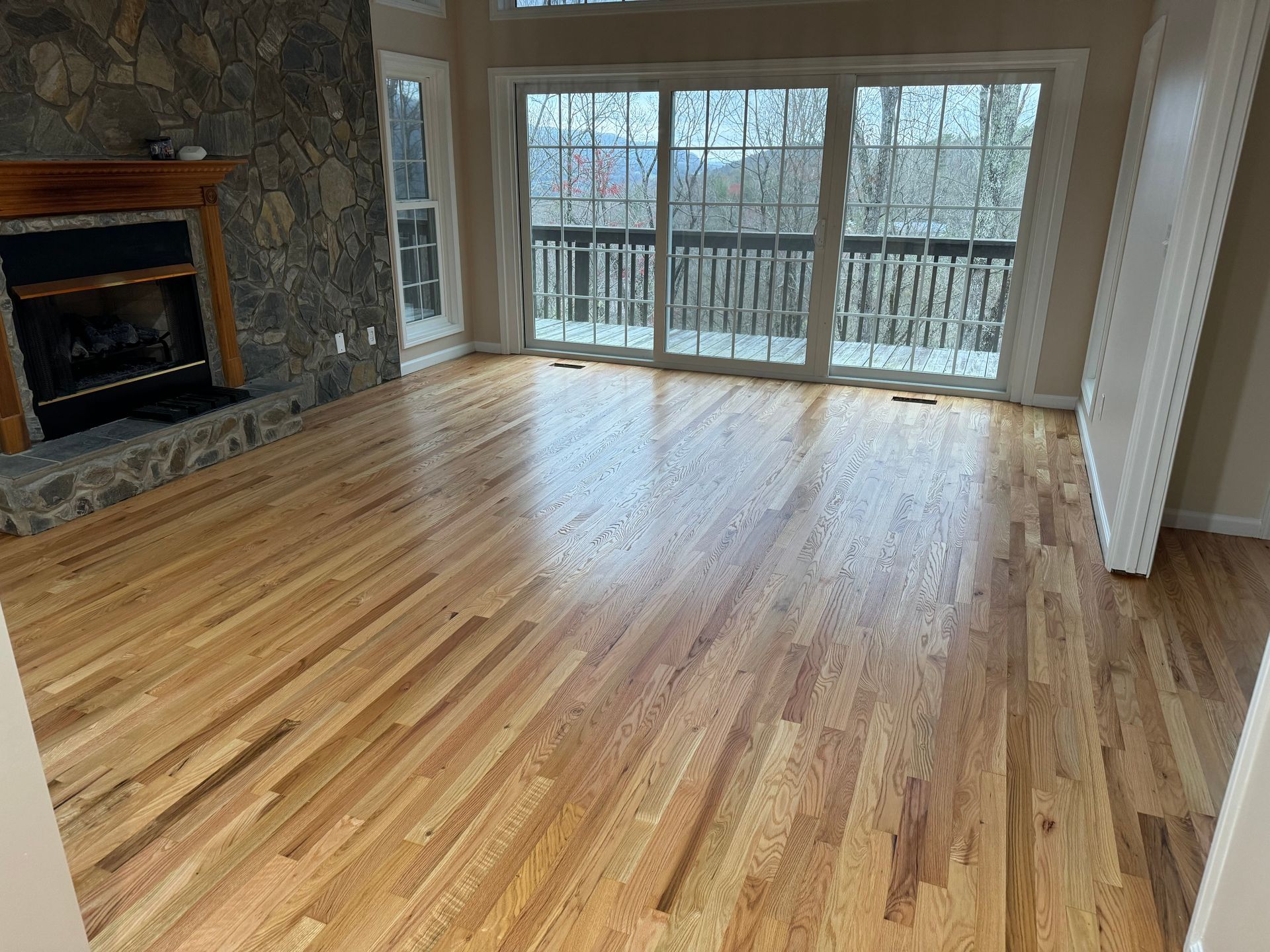 A living room with hardwood floors and a fireplace.