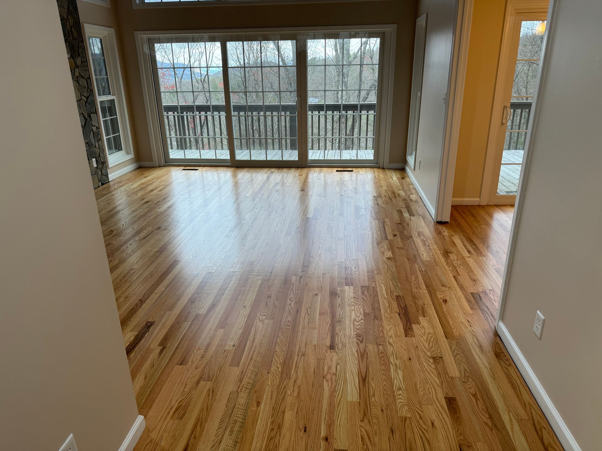 A living room with hardwood floors and sliding glass doors.
