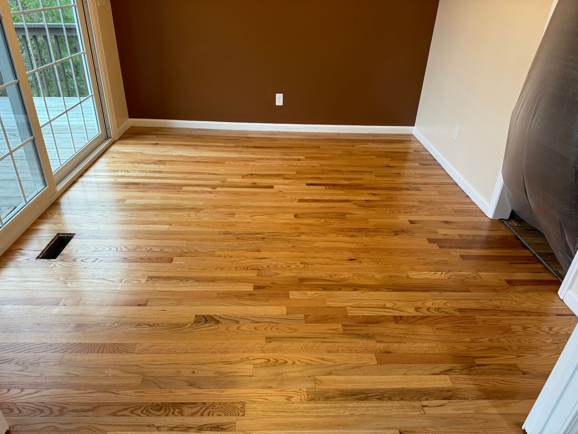 A living room with hardwood floors and a sliding glass door.