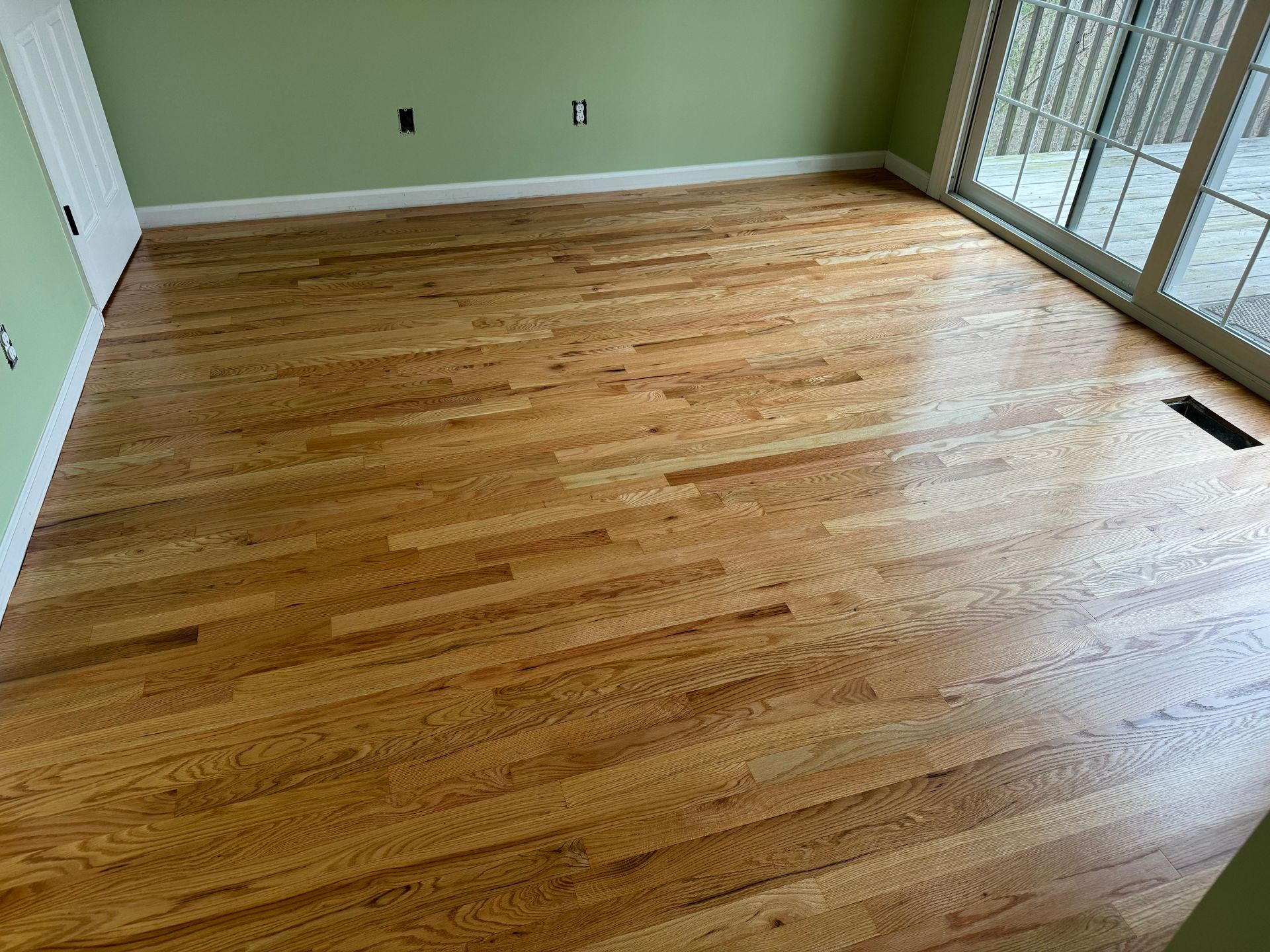 A living room with hardwood floors and green walls.