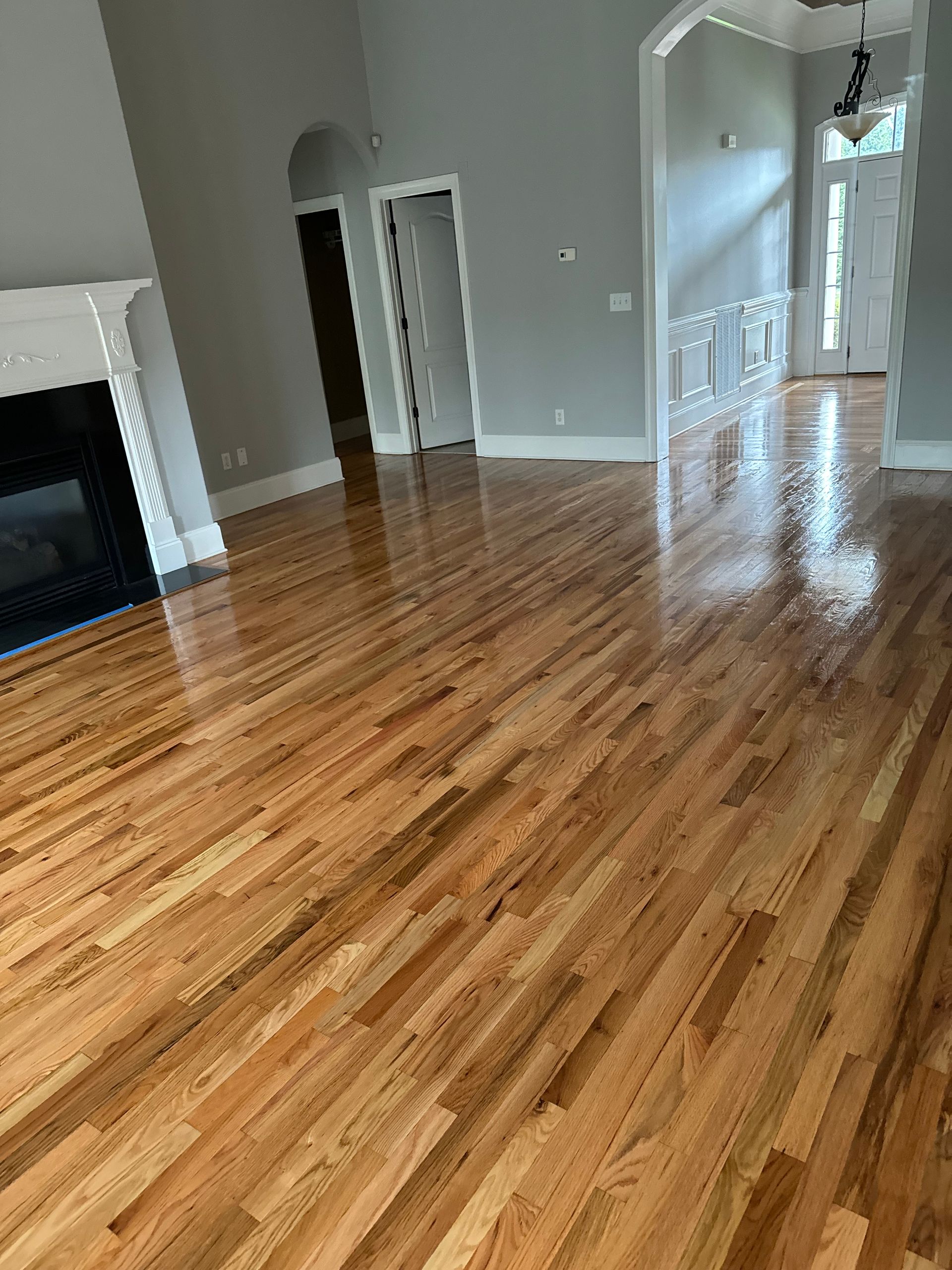 A living room with hardwood floors and a fireplace.