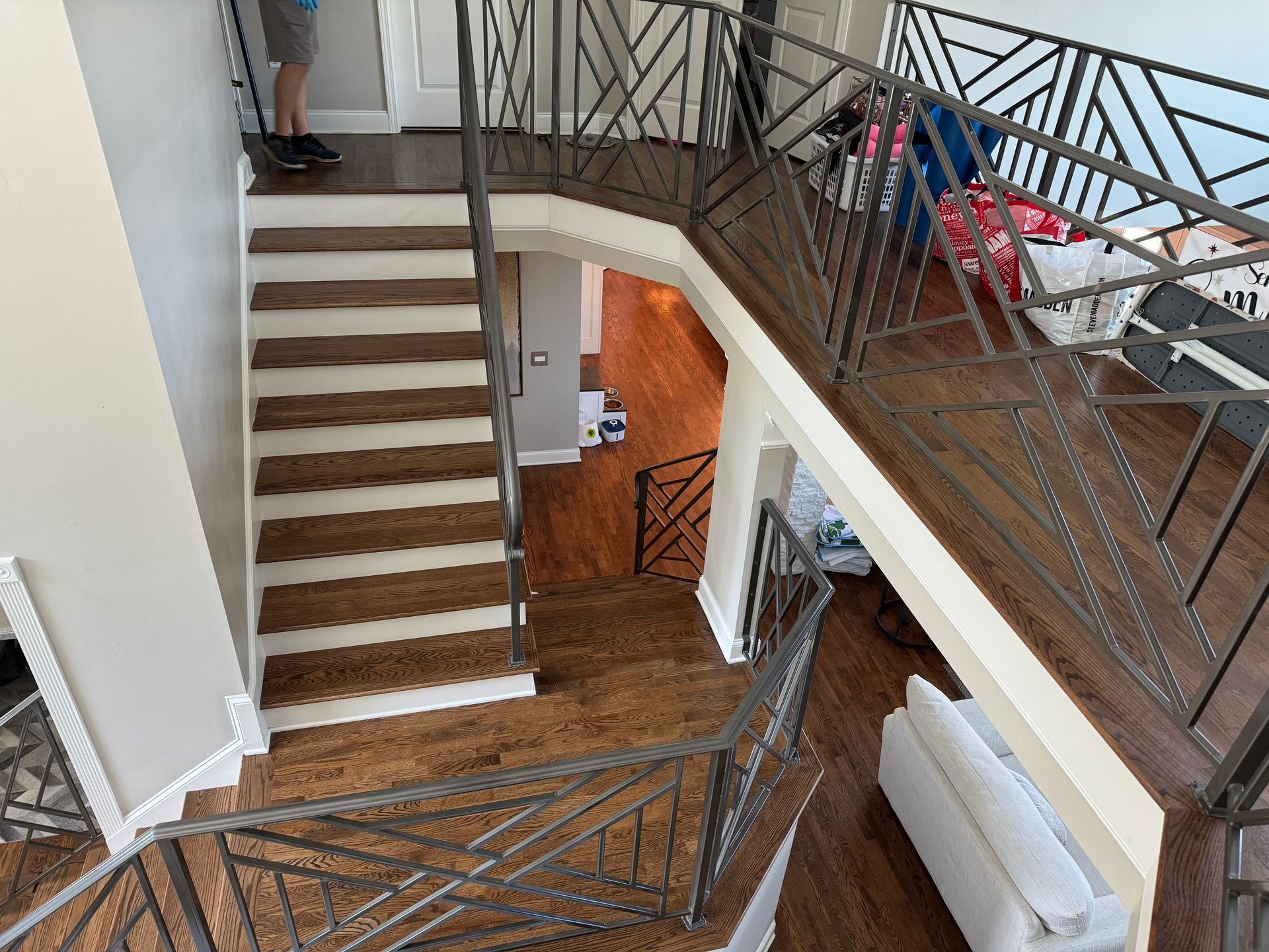 An aerial view of a staircase in a house with a wrought iron railing.