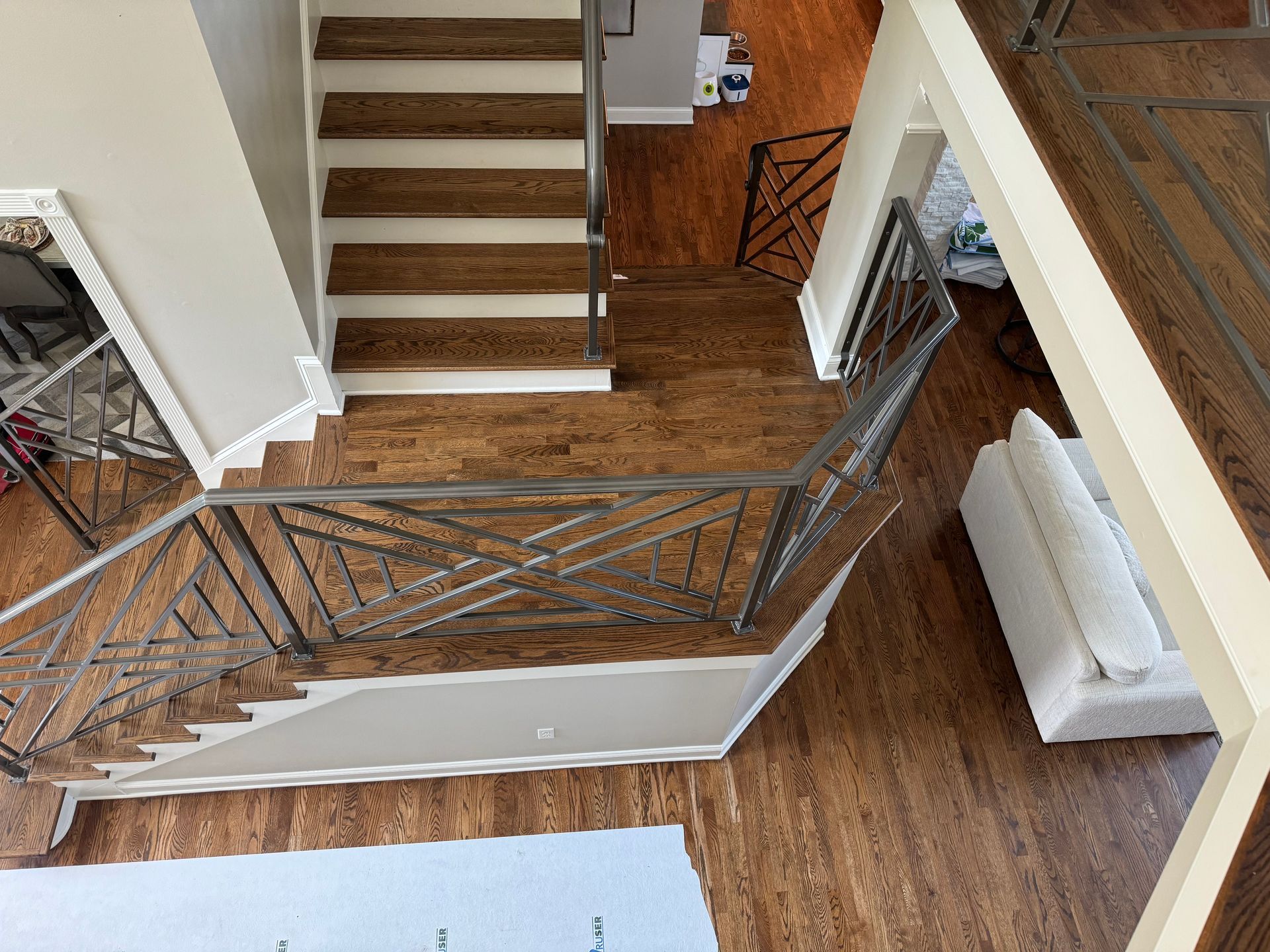 An aerial view of a staircase with wooden steps and a metal railing.