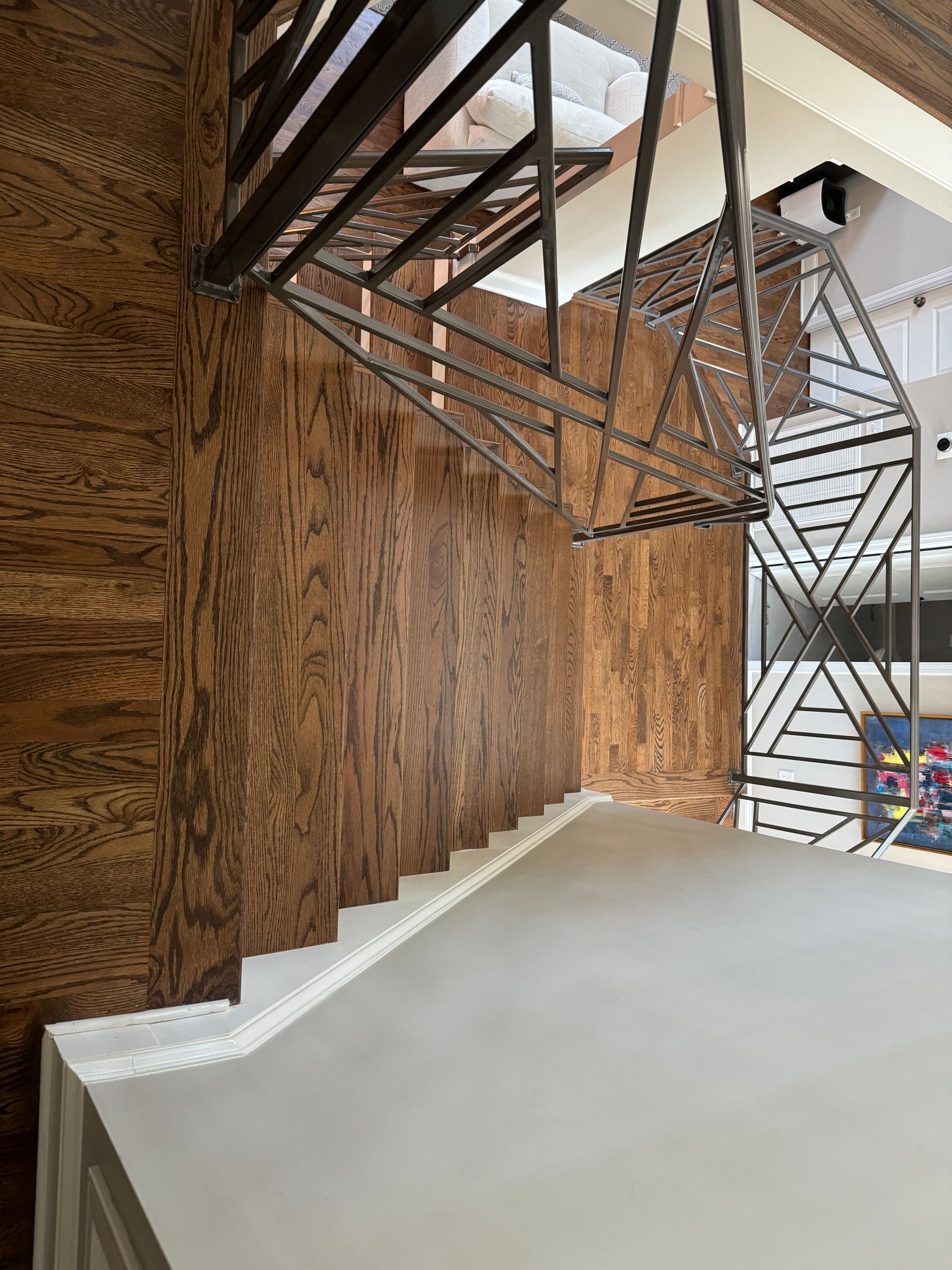 A wooden staircase with a metal railing in a room.