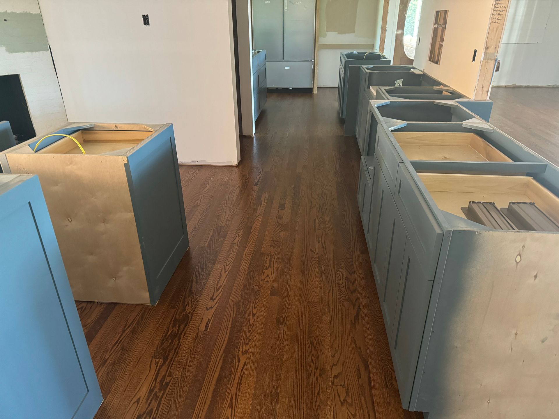 A row of cabinets are lined up on a wooden floor