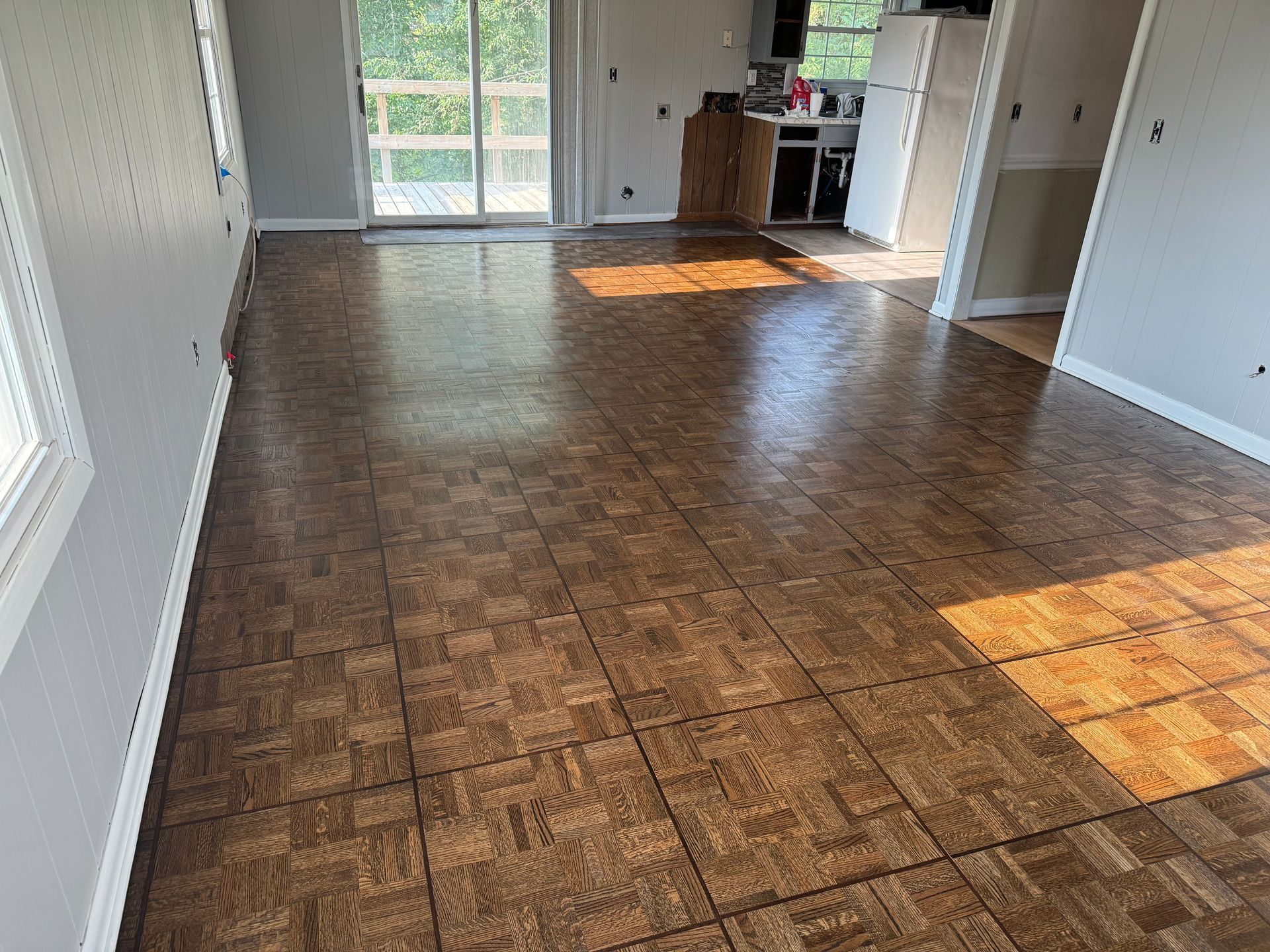 A living room with a wooden floor and a sliding glass door.