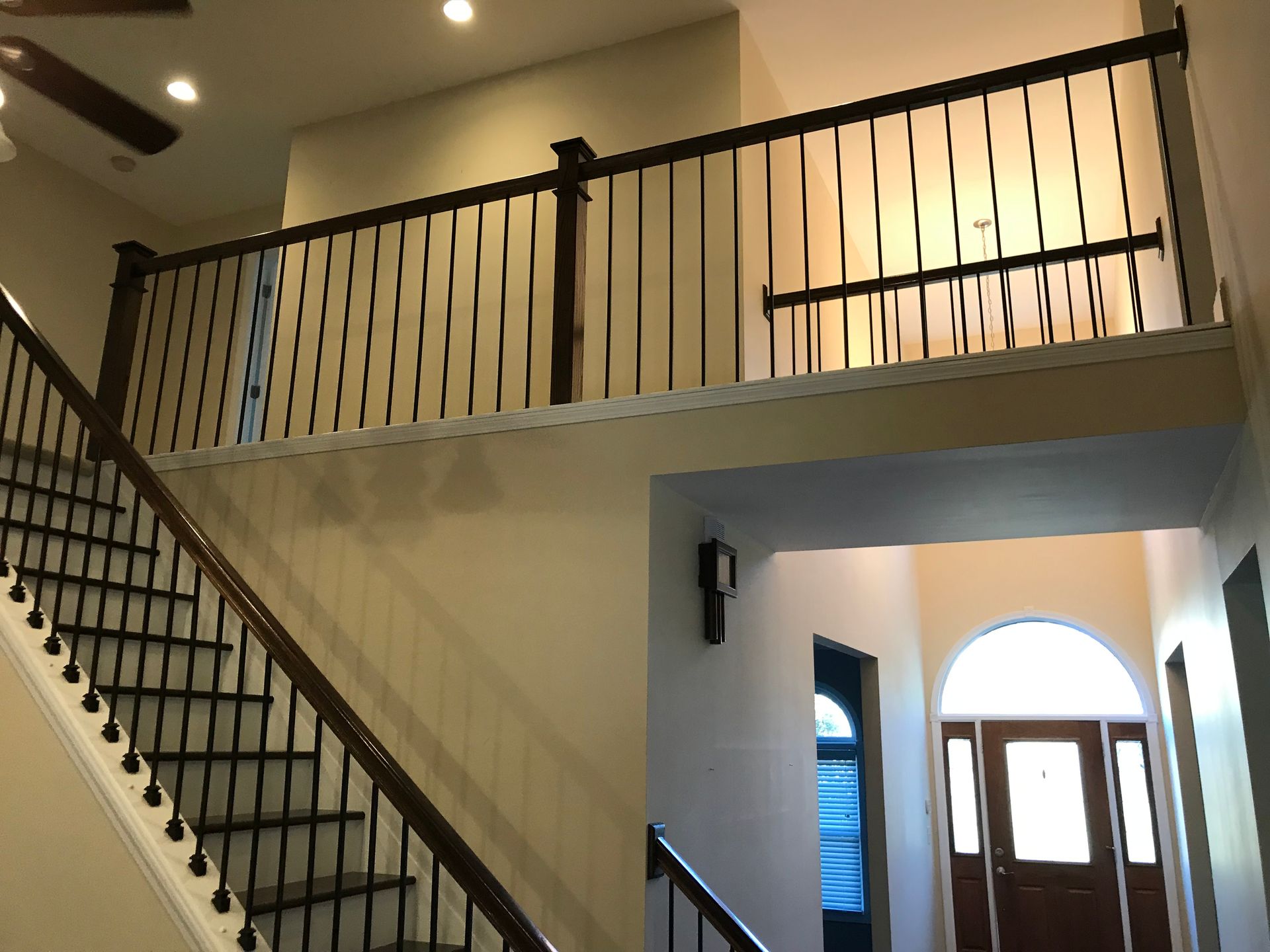 A staircase in a house with a balcony above it