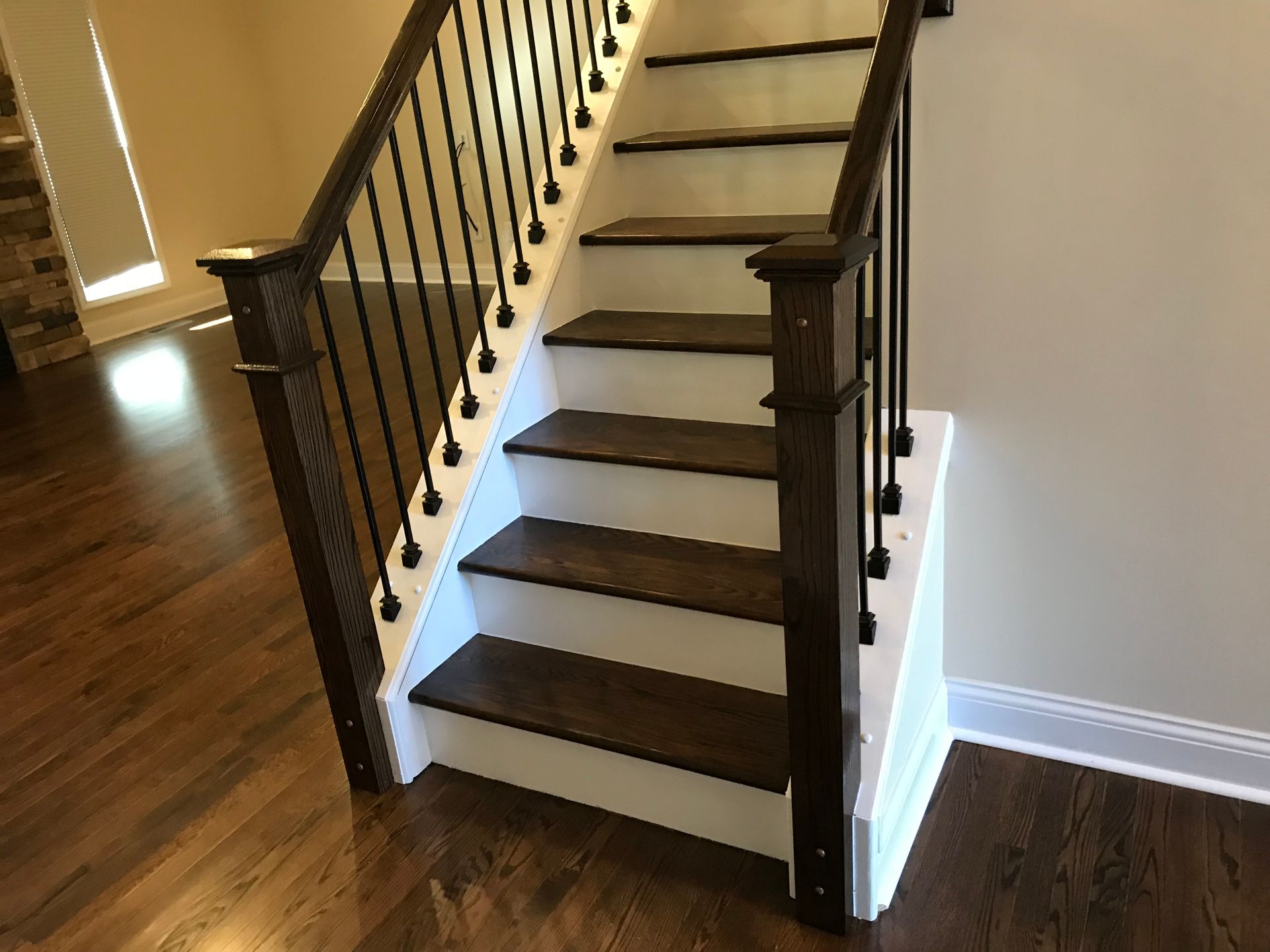 A staircase with wooden steps and a black railing in a house.