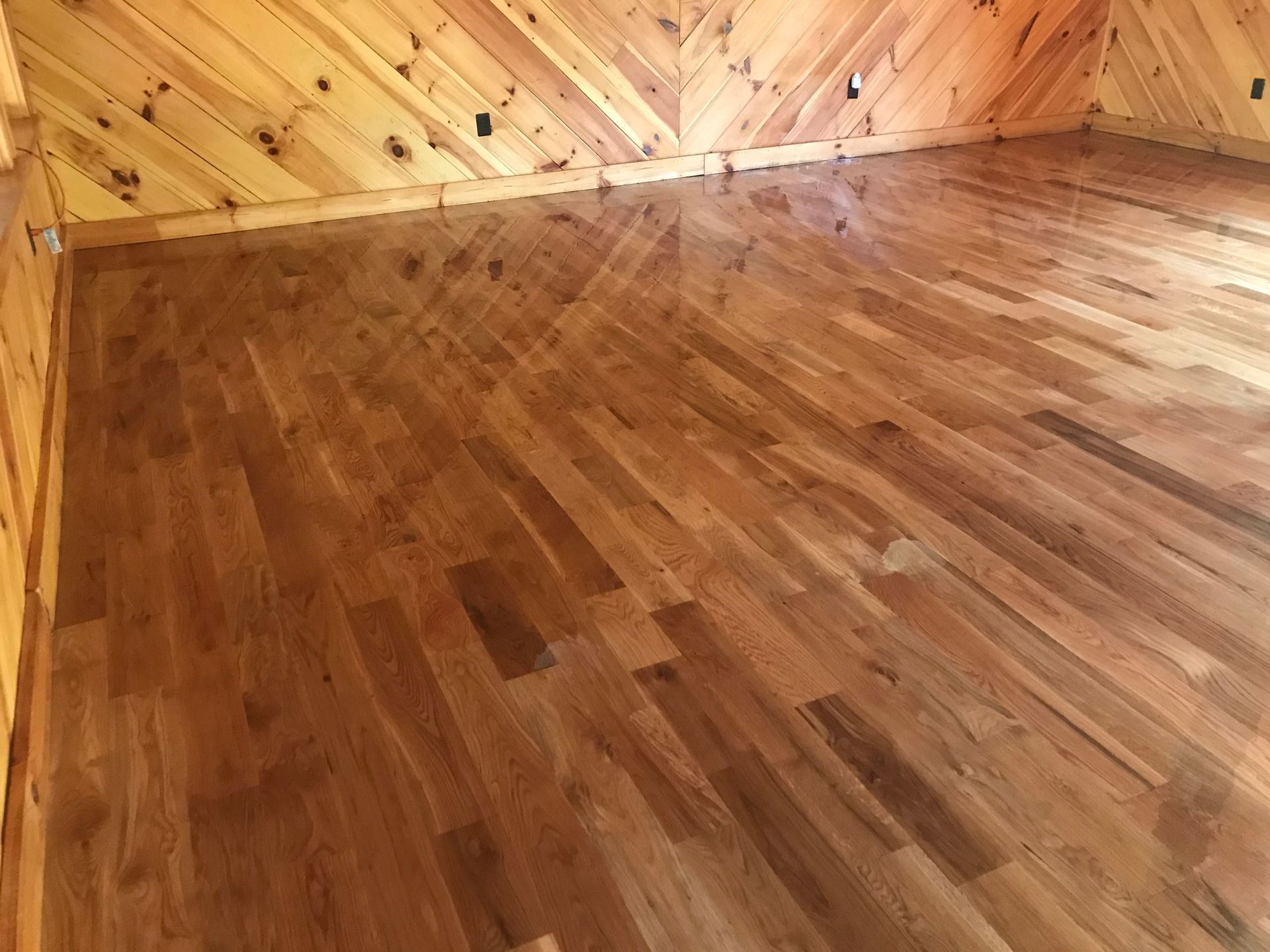 A room with a wooden floor and wooden walls.