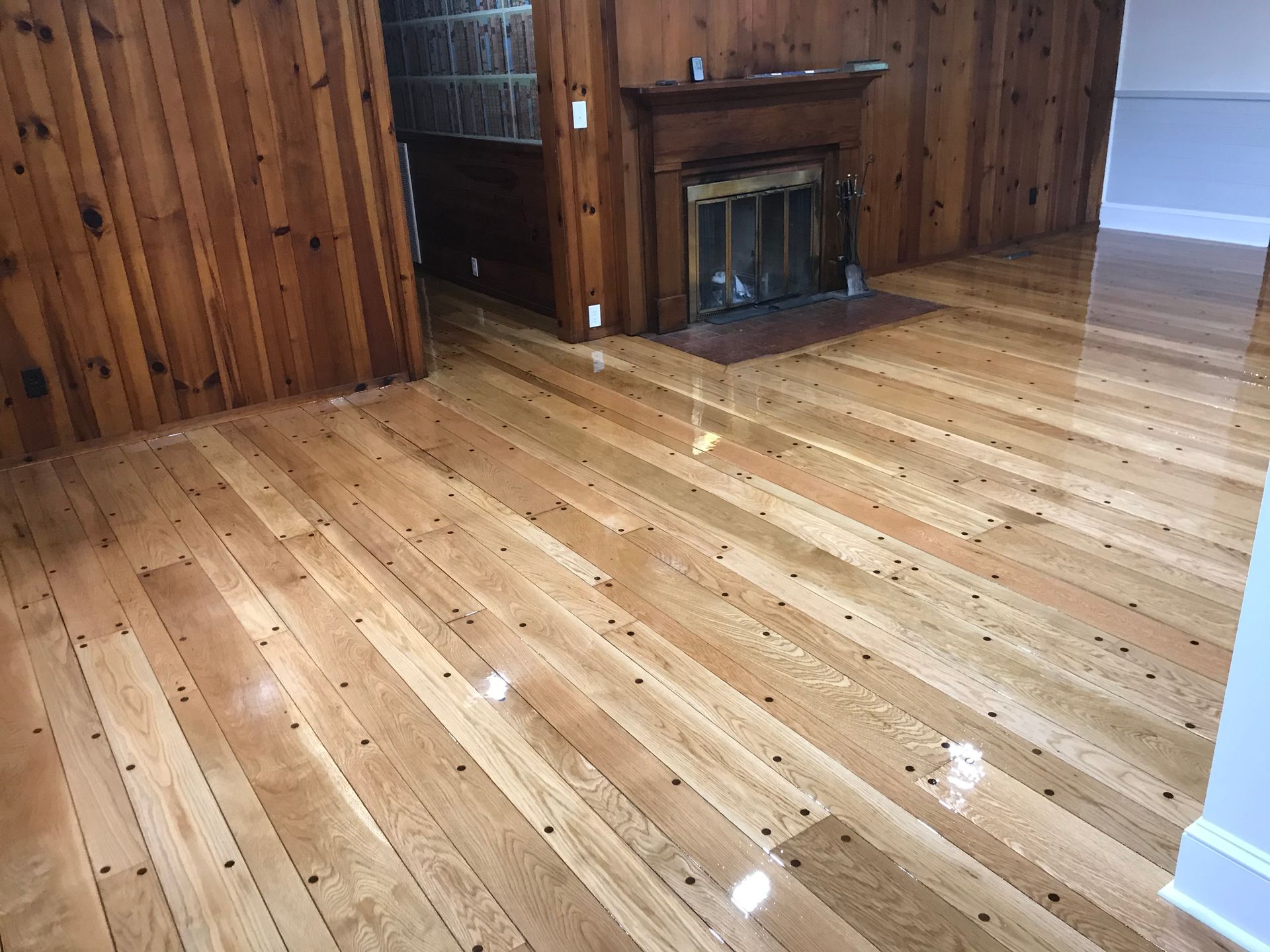 A living room with hardwood floors and a fireplace.