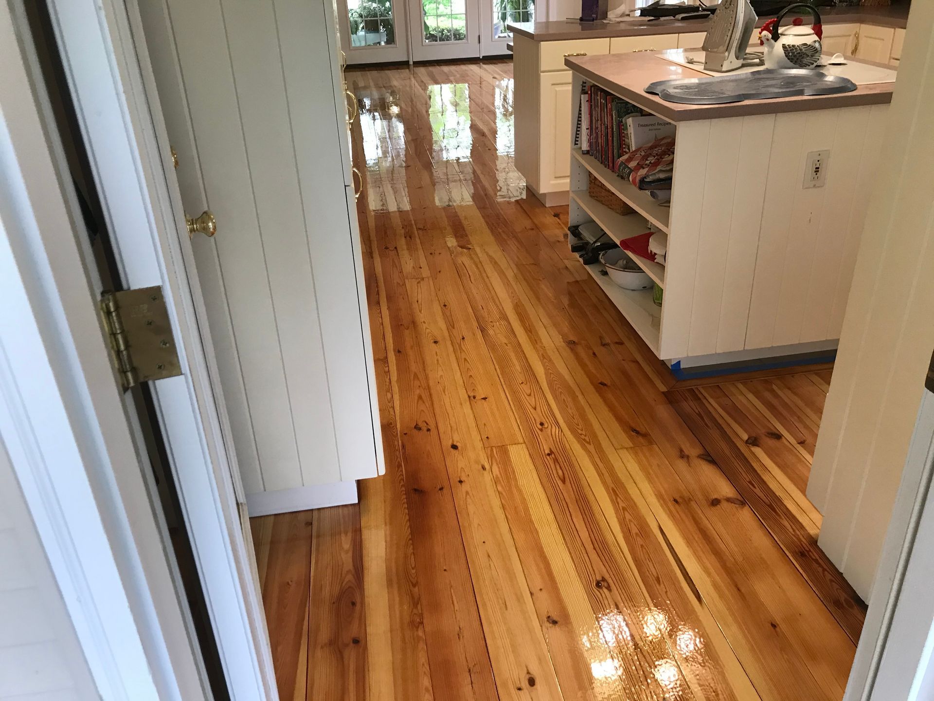 A kitchen with a wooden floor and a white cabinet