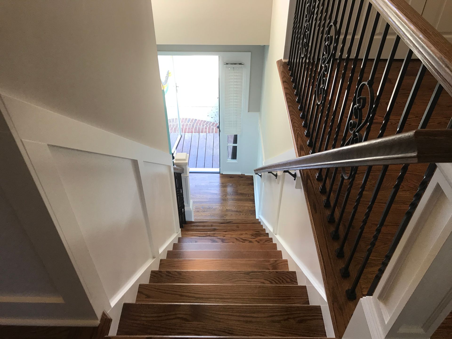 A wooden staircase with a wrought iron railing leading up to the second floor of a house.
