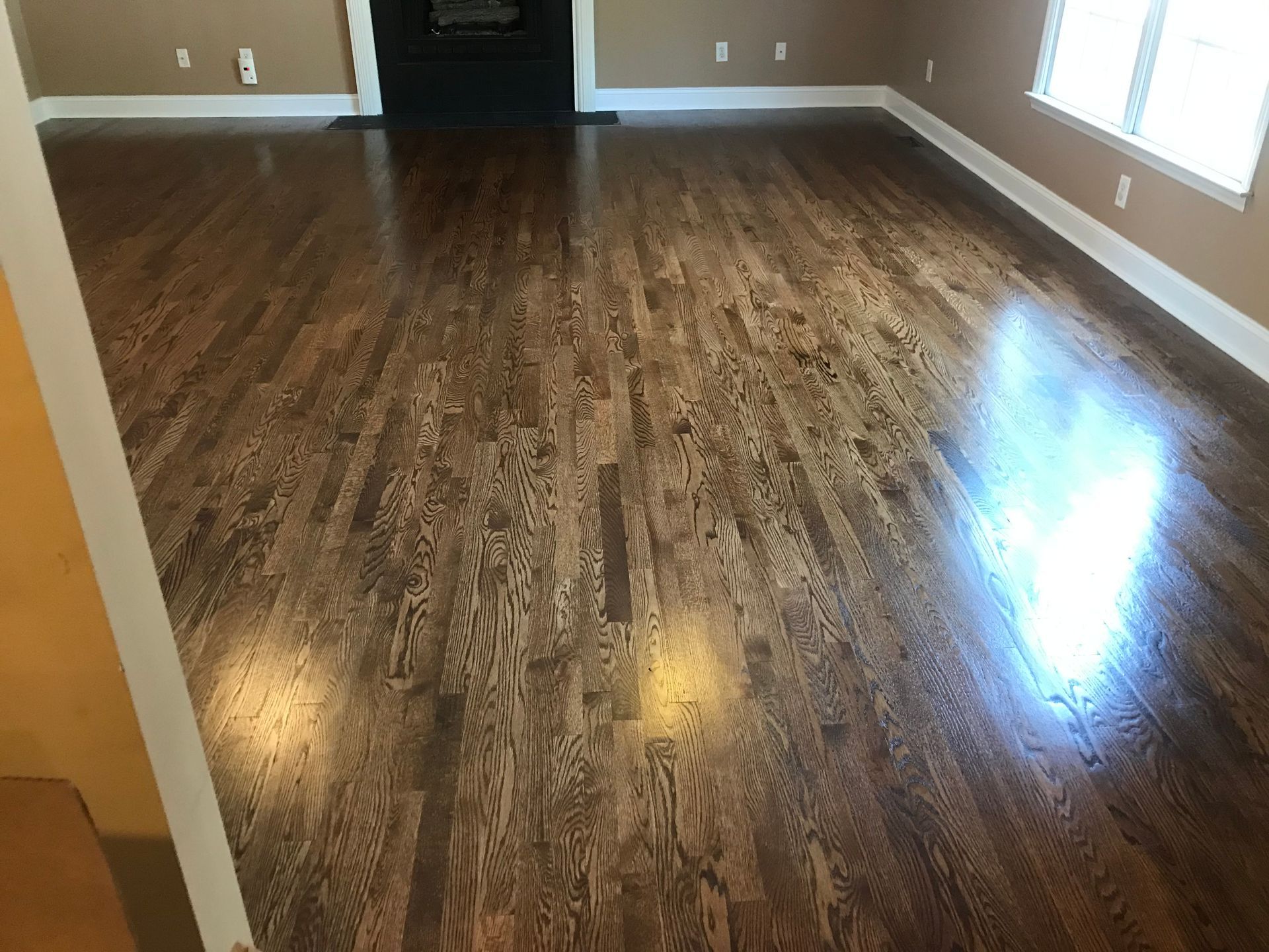 A living room with hardwood floors and a fireplace.