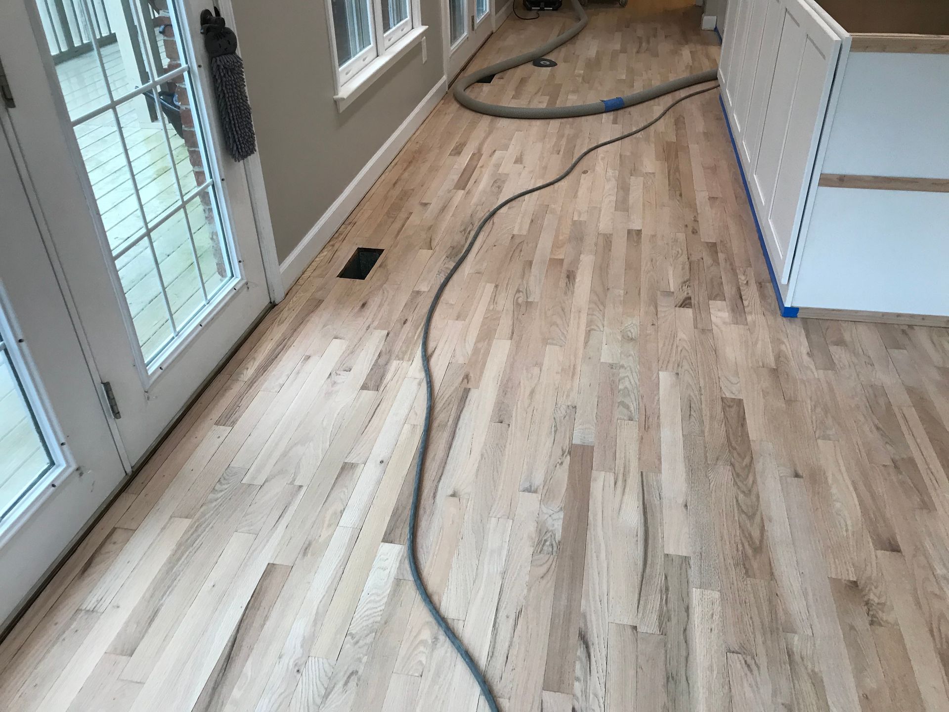 A vacuum cleaner is sitting on a wooden floor in a room.