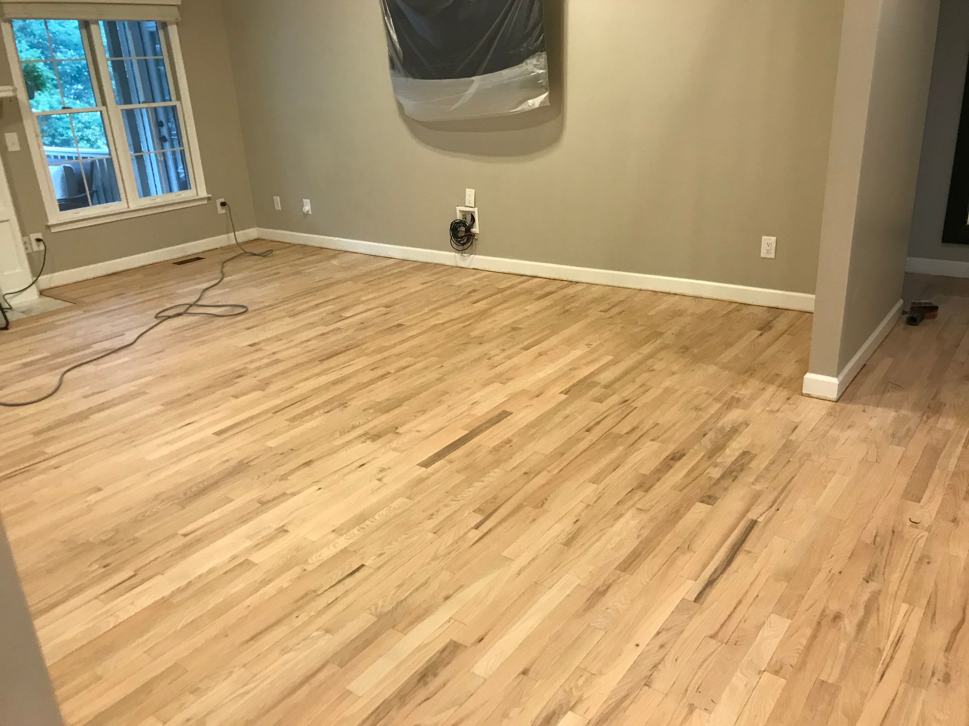 A living room with hardwood floors and a painting on the wall.
